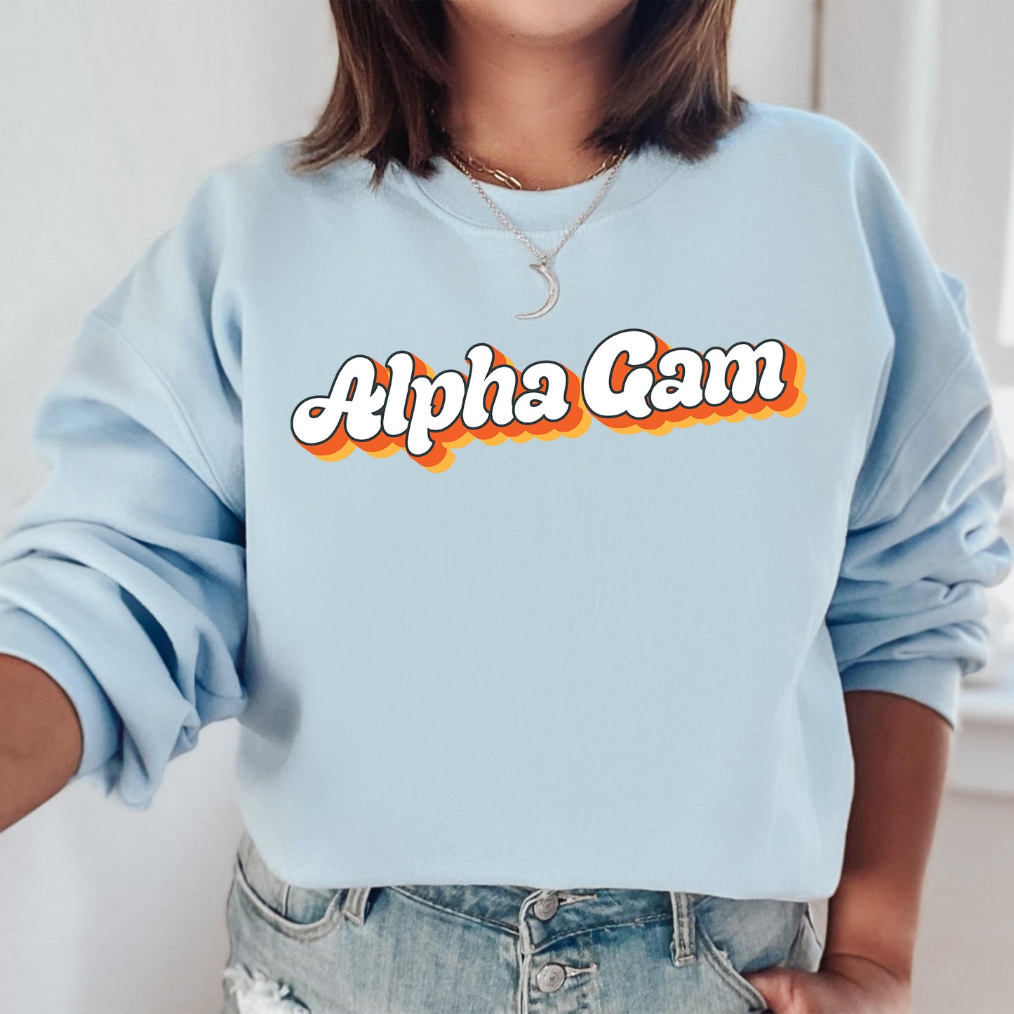 a woman wearing a light blue sweatshirt with the word alpha cam printed on it