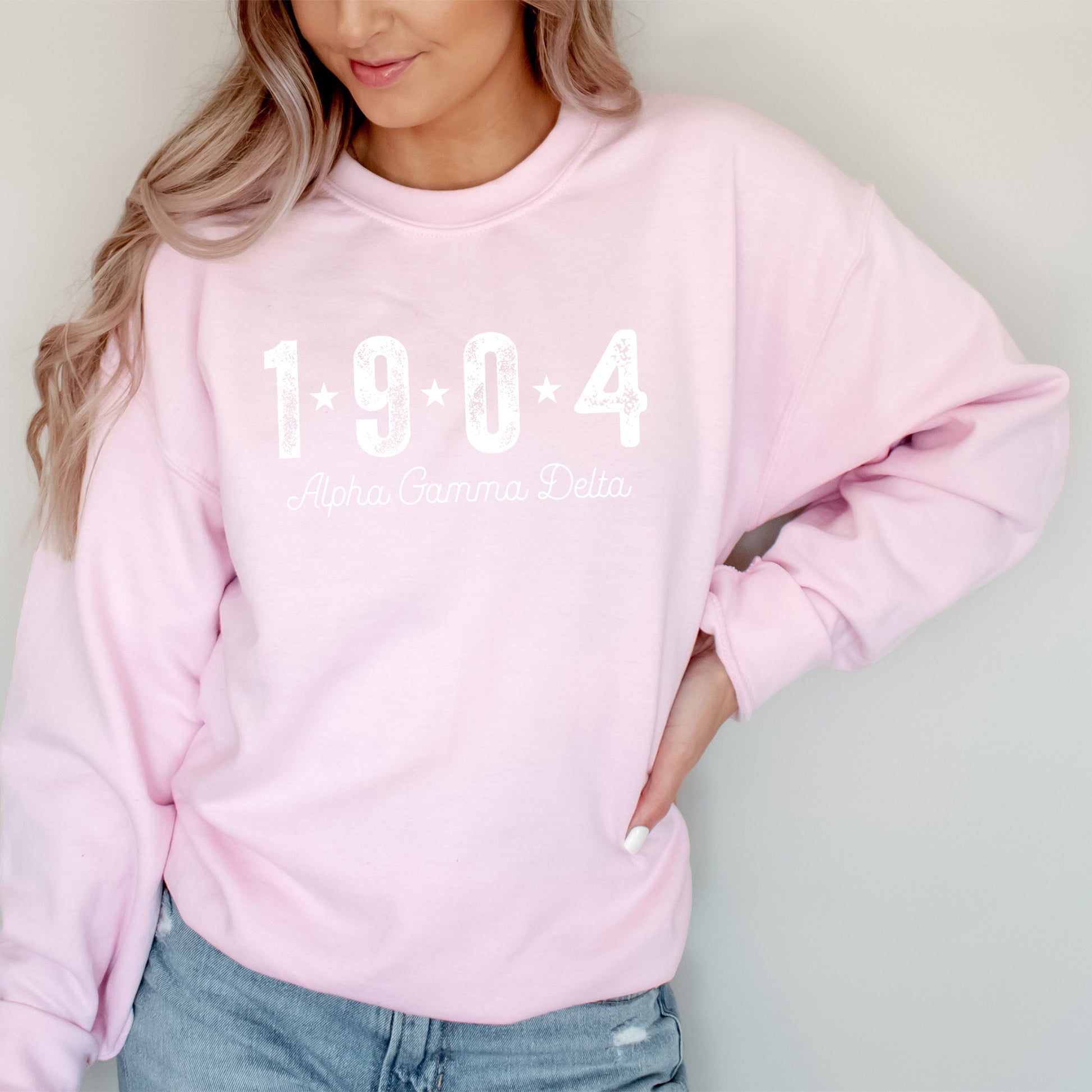 a woman wearing a pink sweatshirt with the year 1994 printed on it