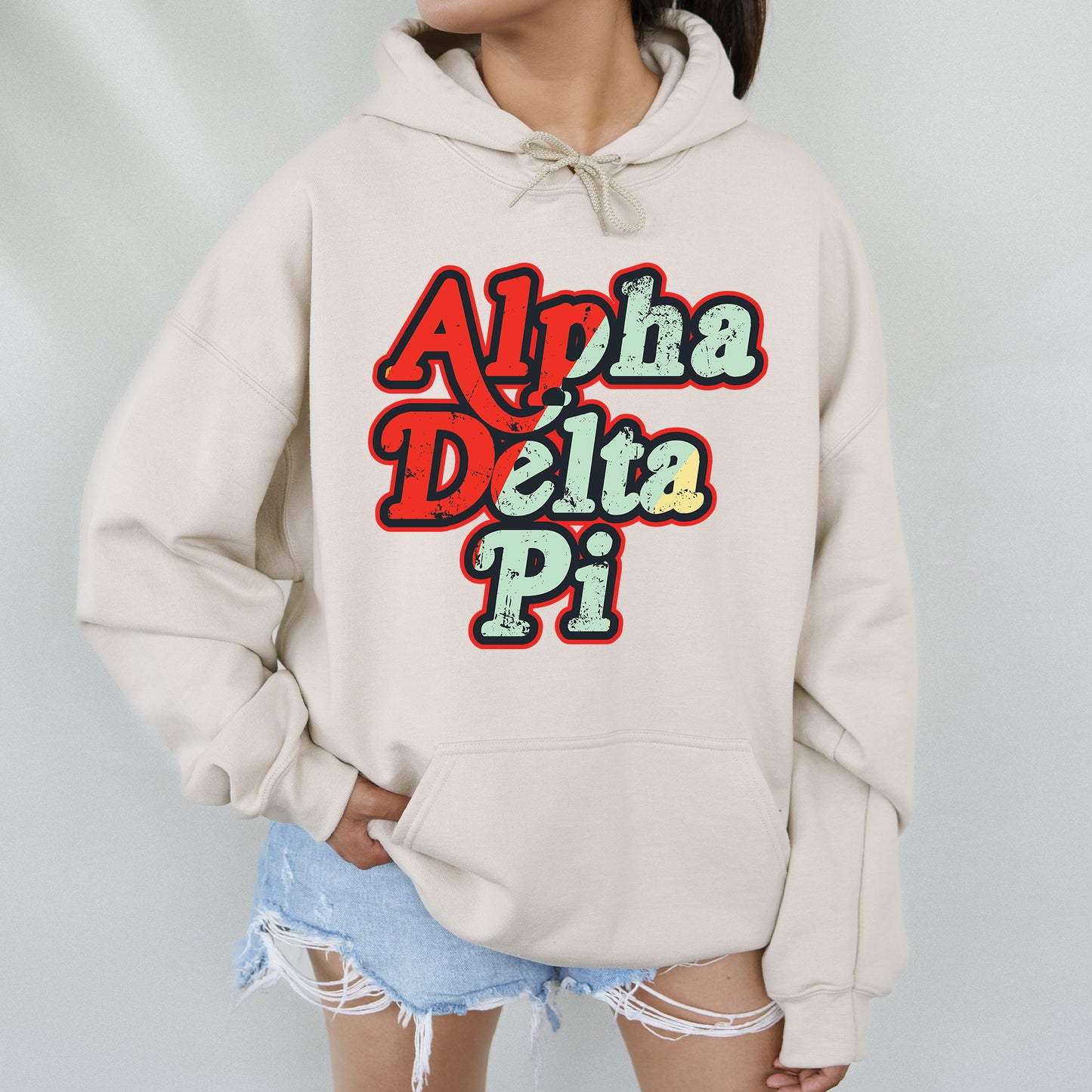 a woman wearing a white sweatshirt with the words alpha delta pi on it