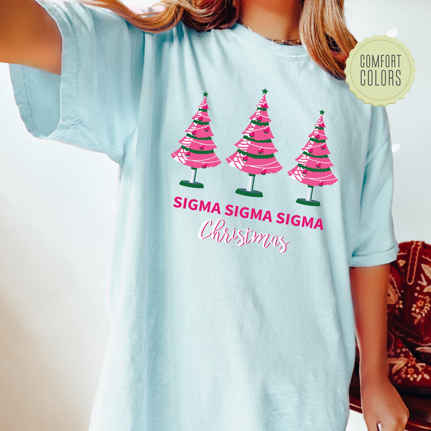 a woman wearing a blue shirt with pink trees on it