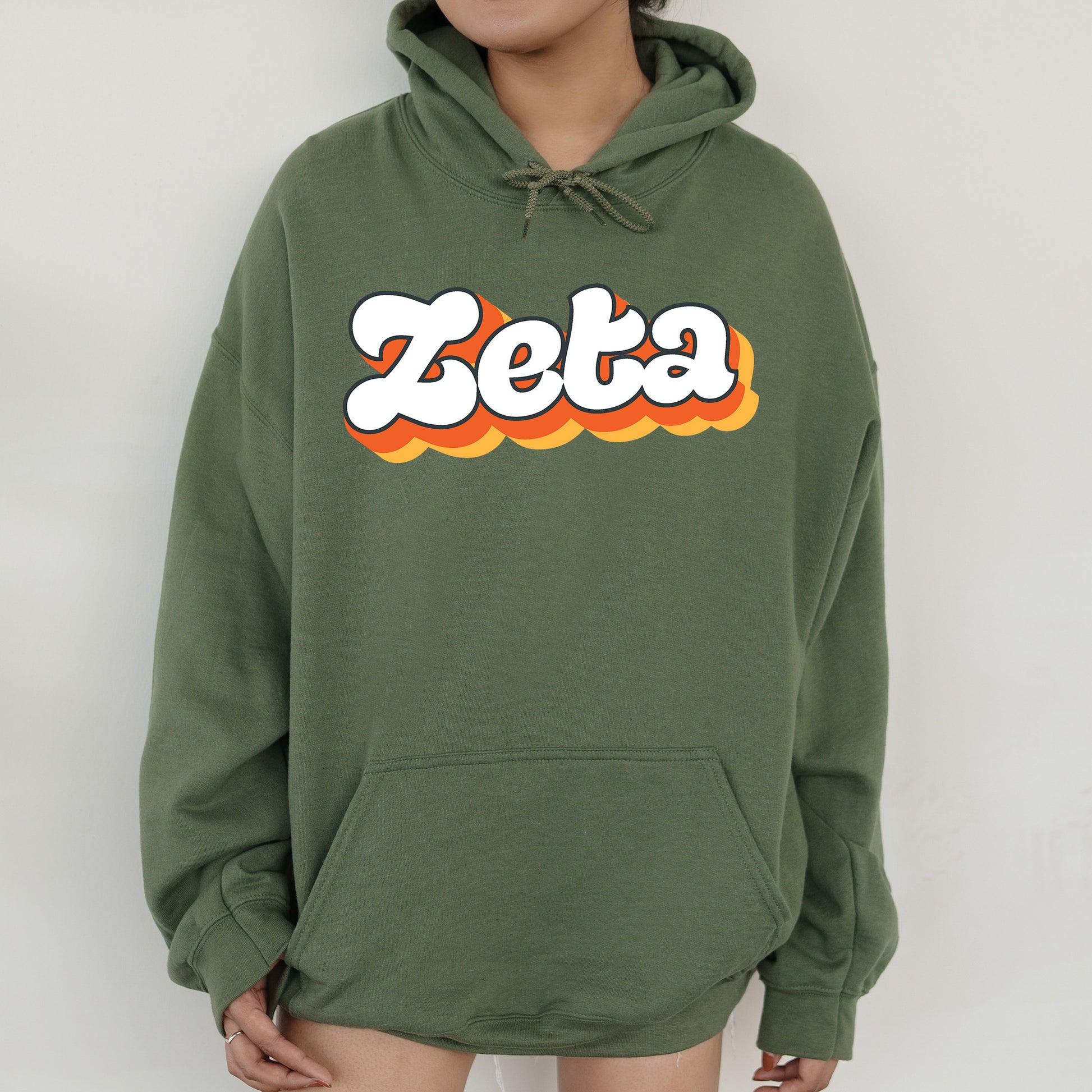 a person wearing a green hoodie with the word zeta printed on it