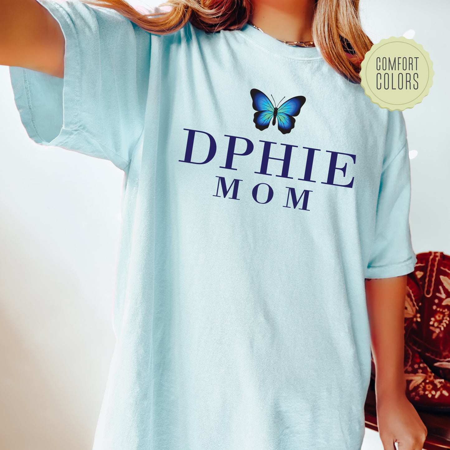 a woman wearing a blue shirt with a butterfly on it