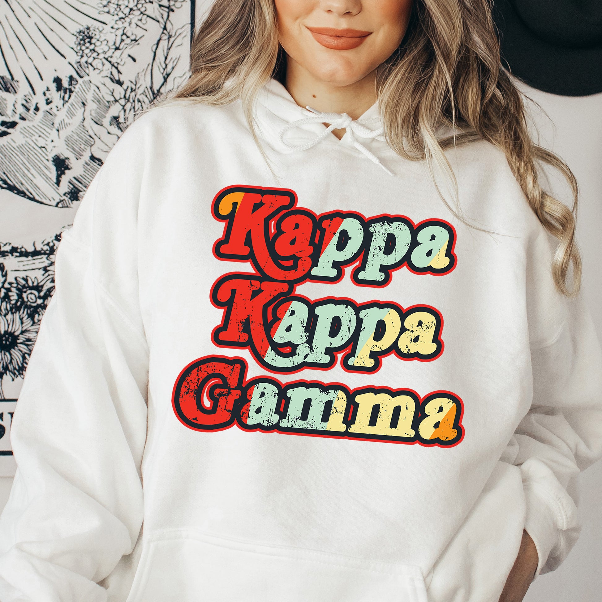 a woman wearing a white hoodie that says kapp kapp gamma
