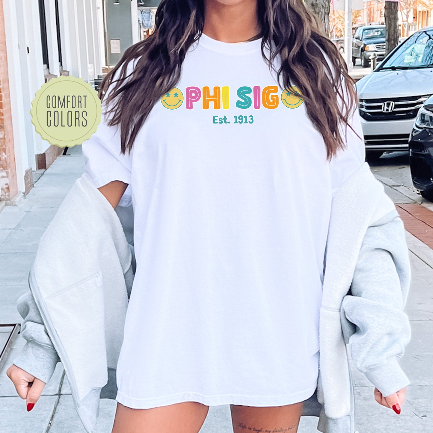 a woman wearing a white shirt with the word phi sig on it