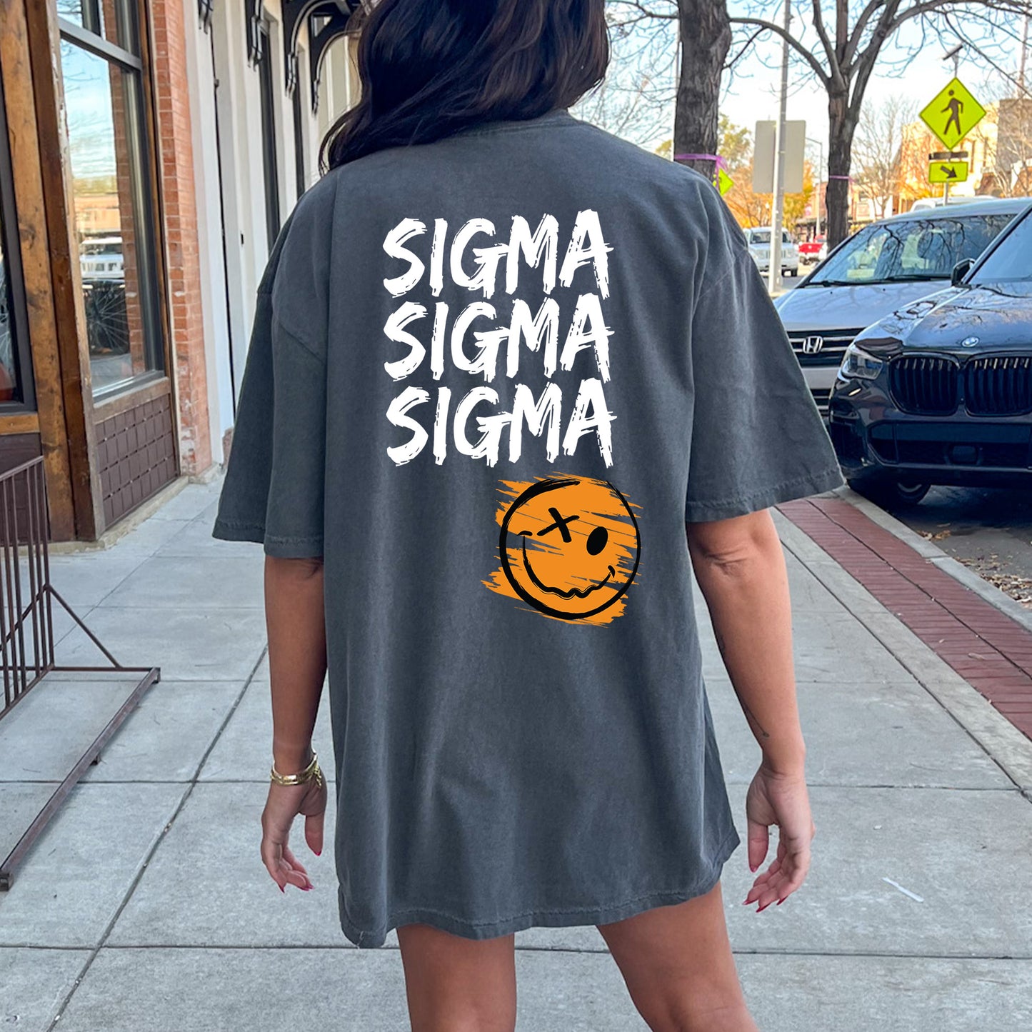 a woman walking down a sidewalk wearing a shirt that says stigma stigma stigma