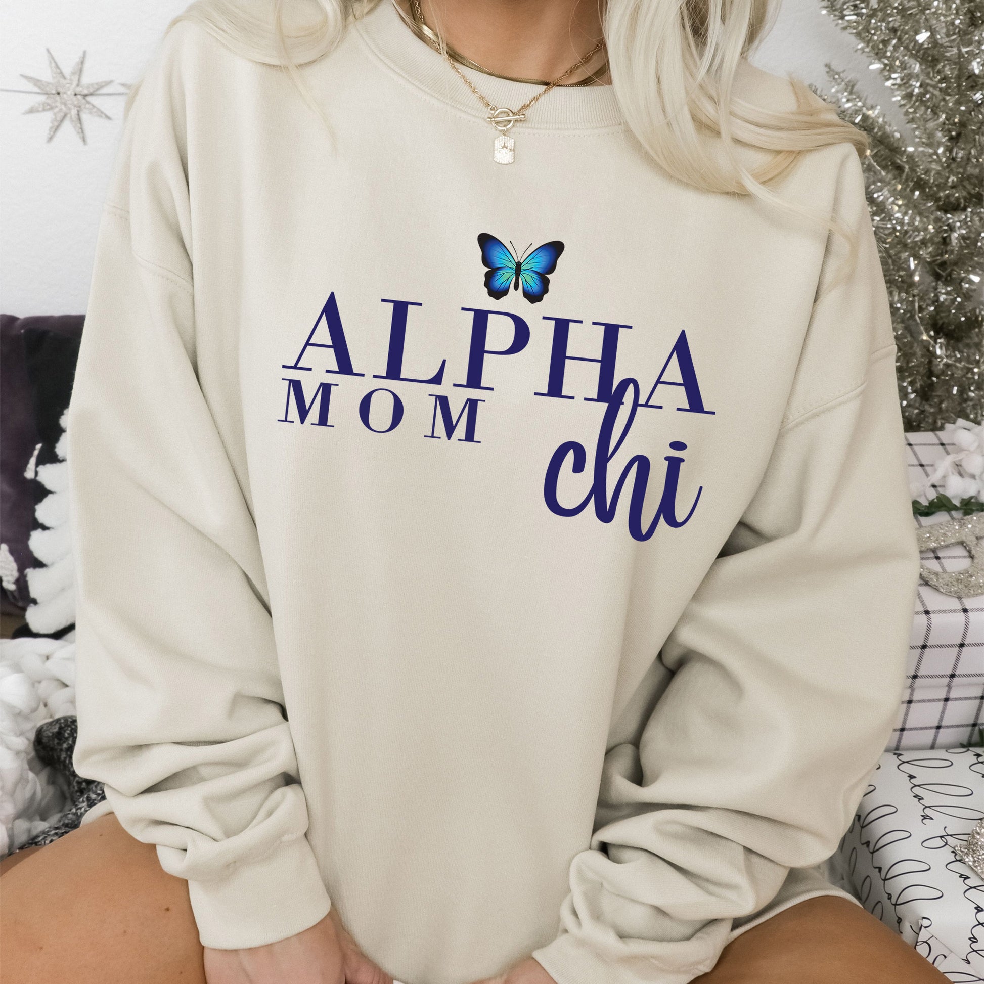 a woman sitting on a bed wearing a sweatshirt