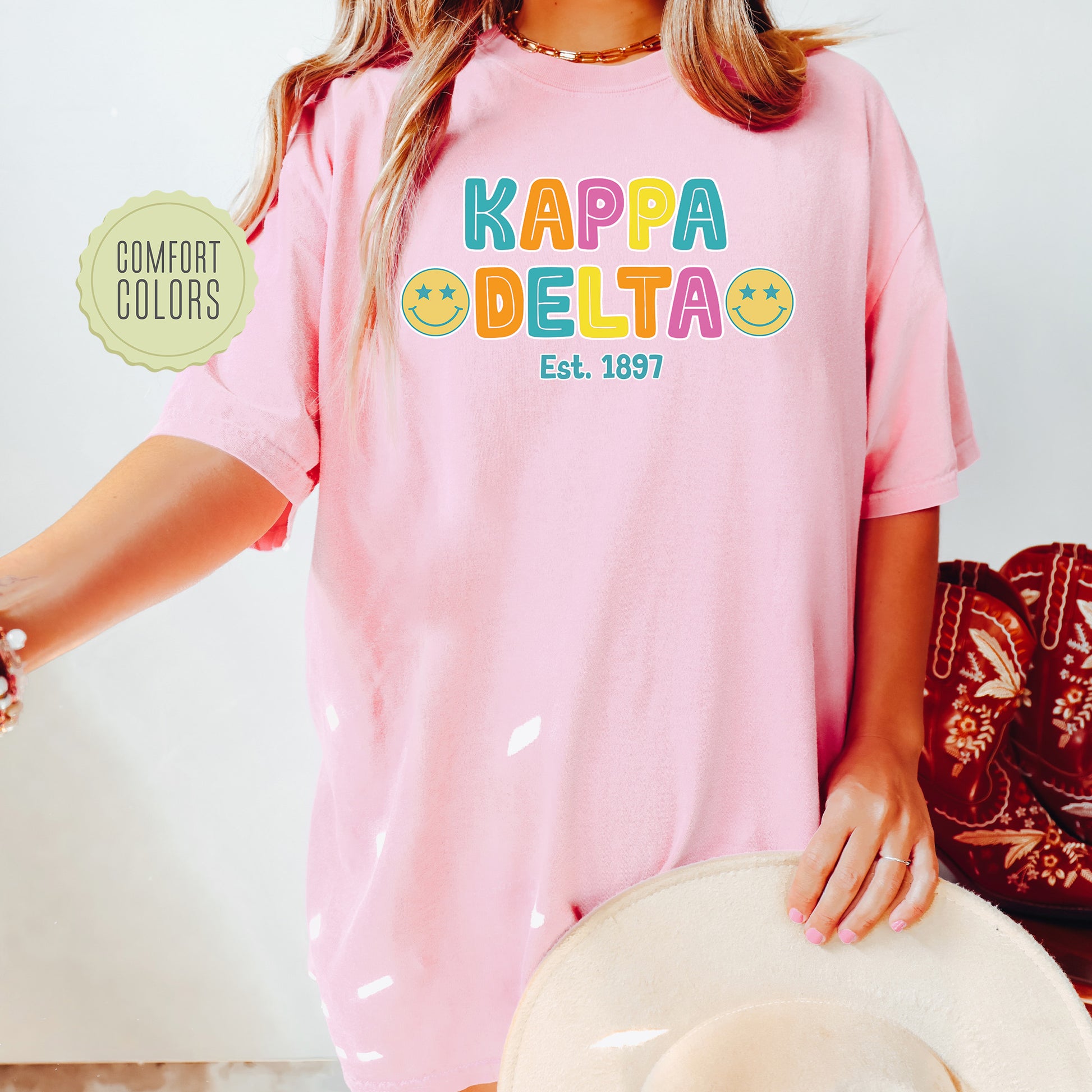 a woman wearing a pink shirt that says kapa delta
