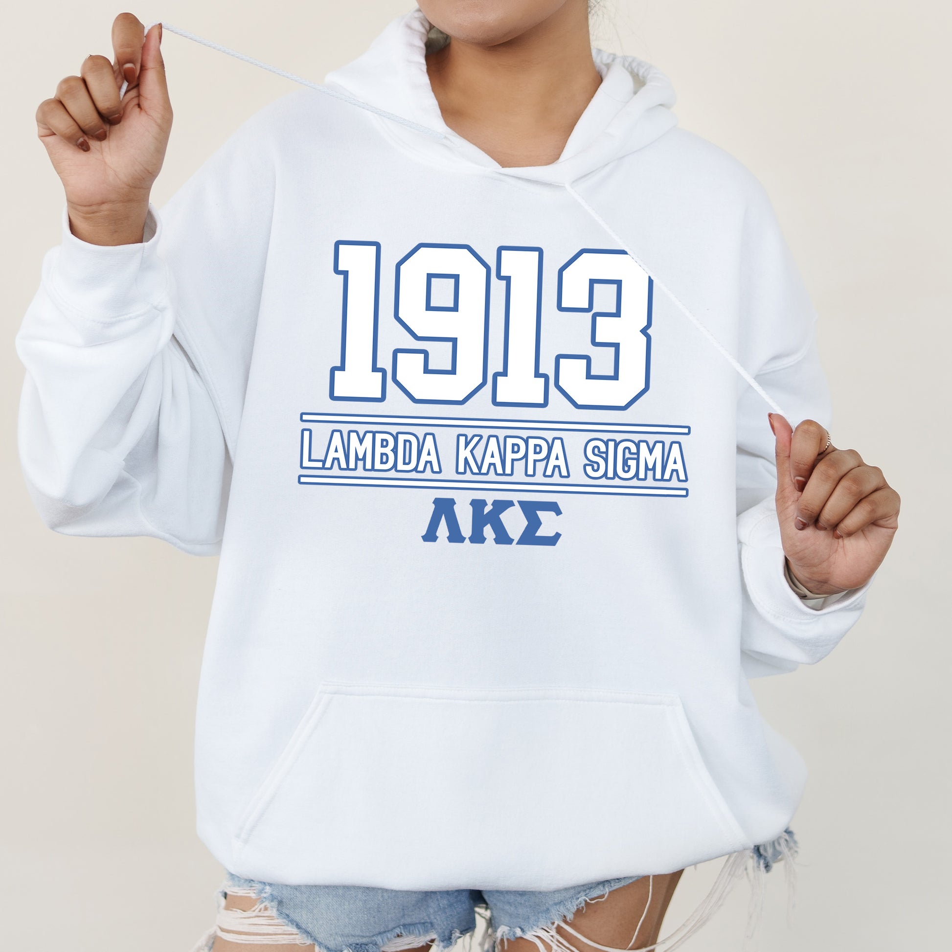 a woman wearing a white hoodie and ripped shorts