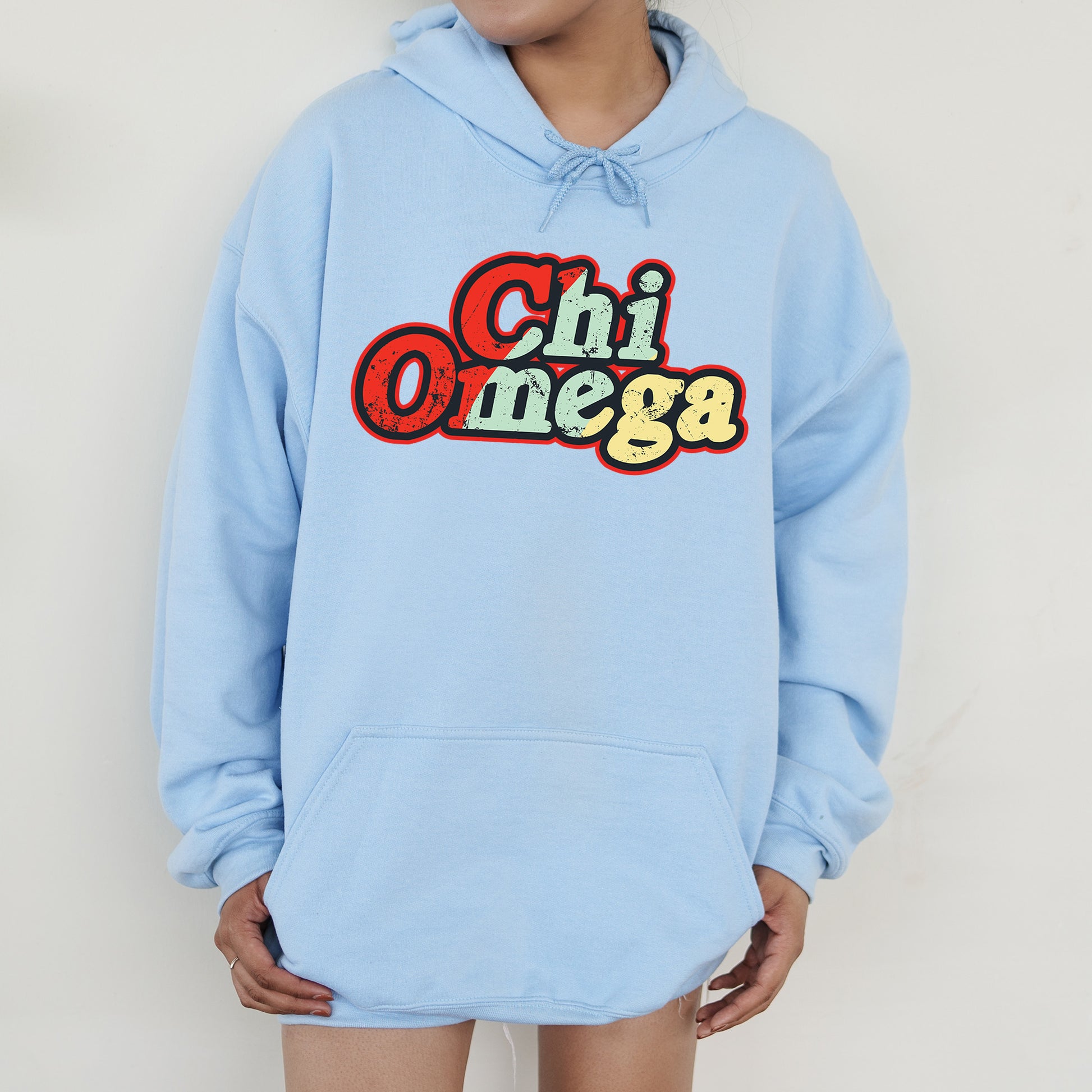 a person wearing a blue hoodie with the word chi omega printed on it