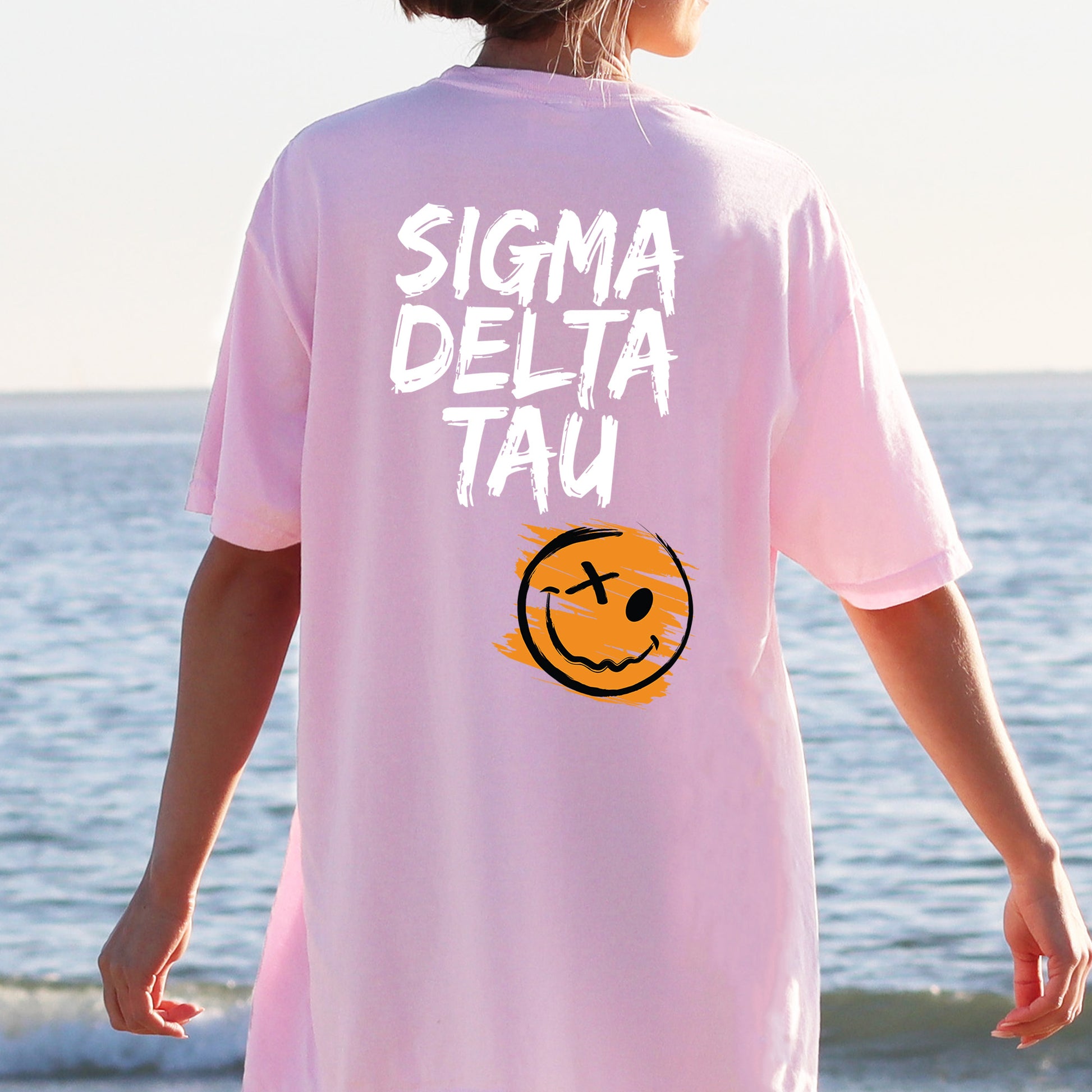 a person wearing a pink shirt with a smiley face on it