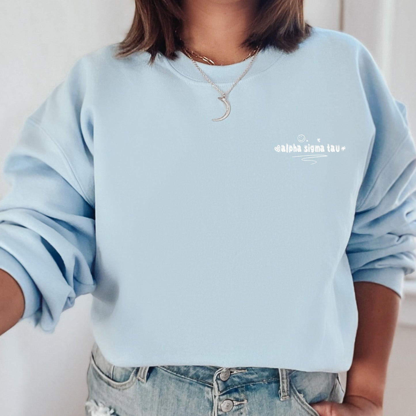 a woman wearing a light blue sweatshirt with the words you are not alone written on