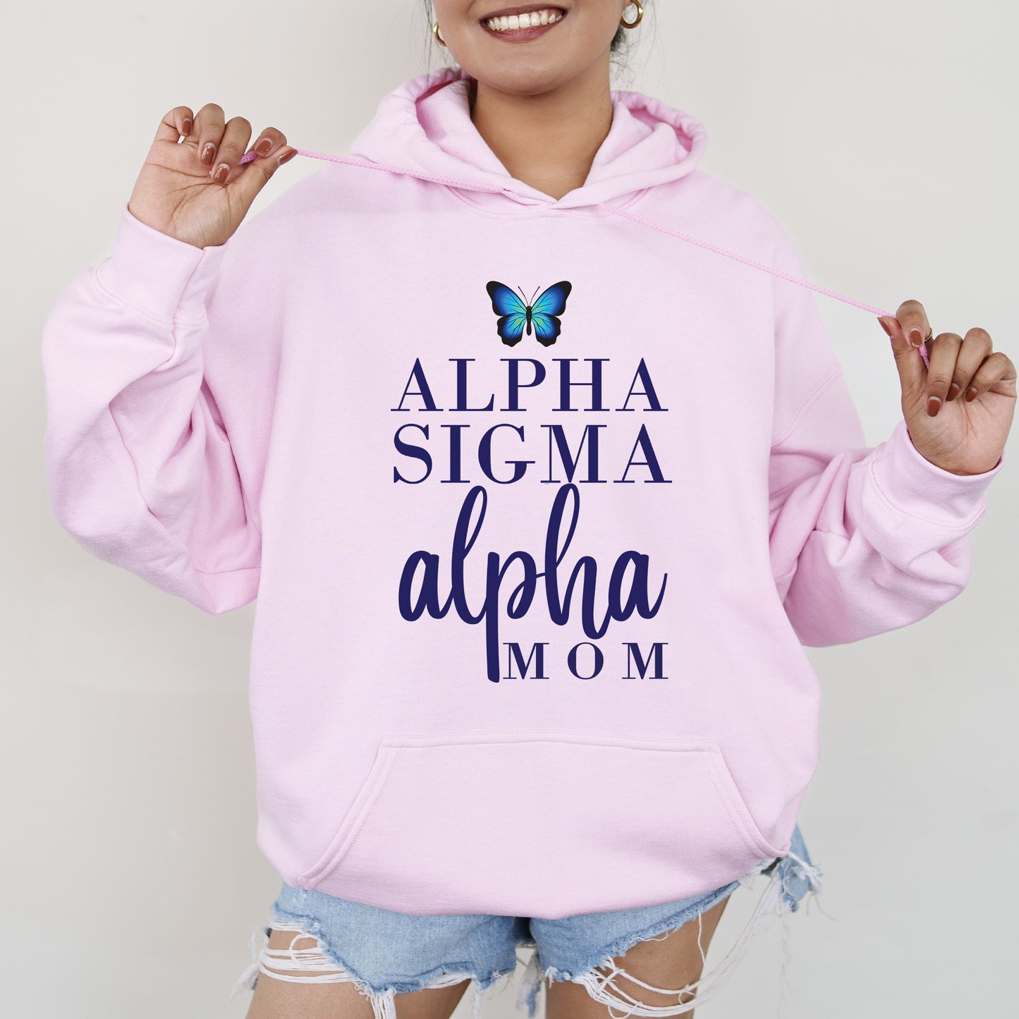a woman wearing a pink hoodie with a butterfly on it
