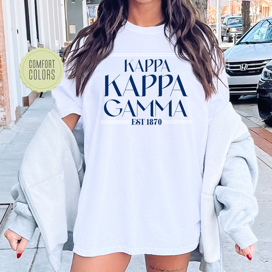 a woman wearing a white t - shirt that says kapa kapa gama