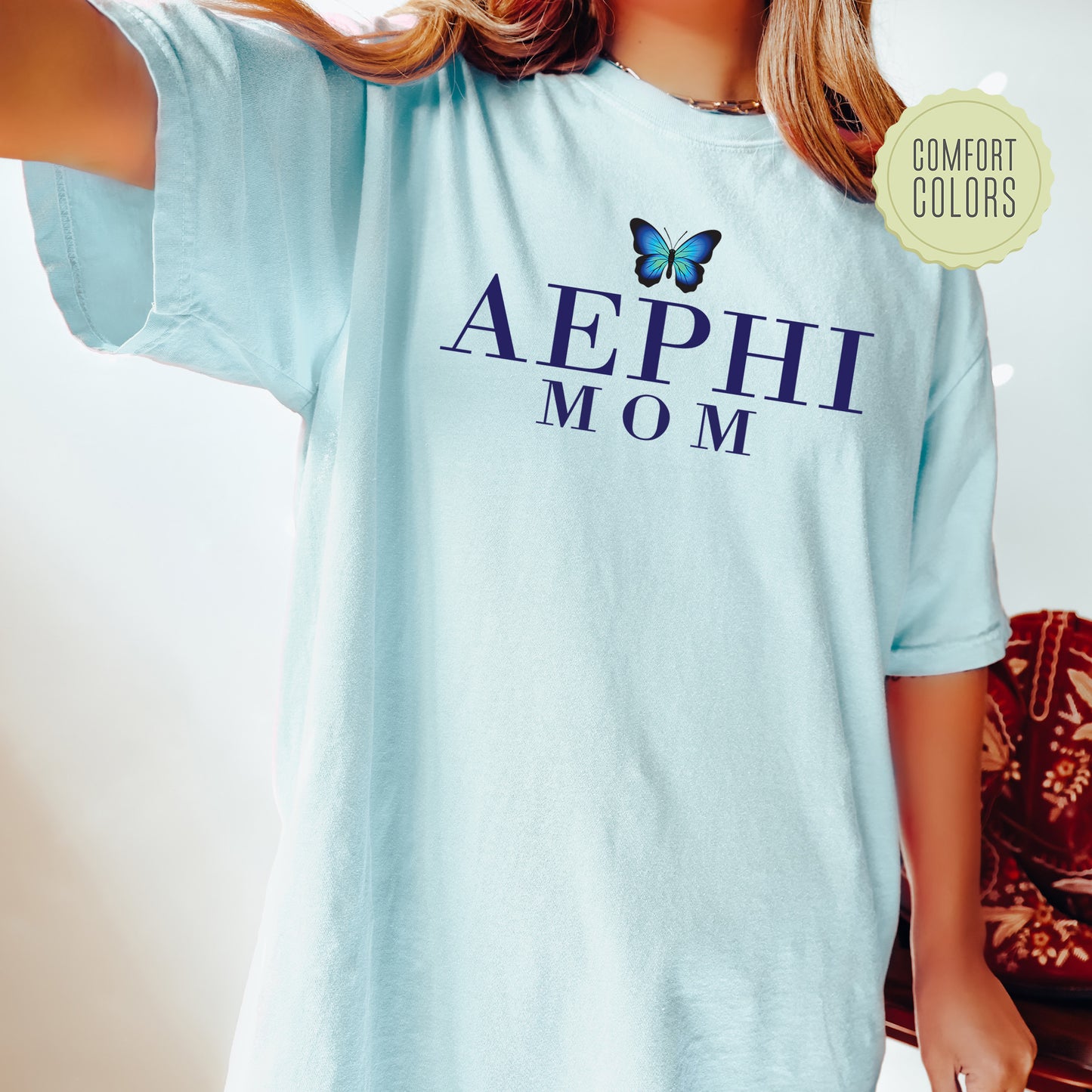 a woman wearing a blue shirt with a butterfly on it