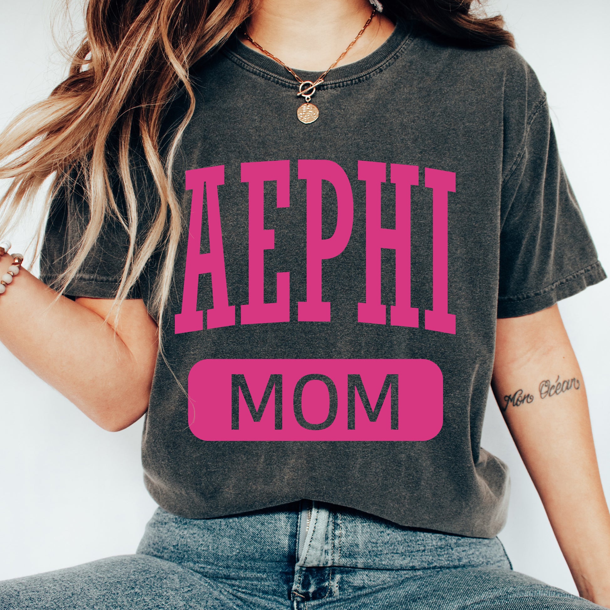 a woman wearing a shirt that says aephi mom