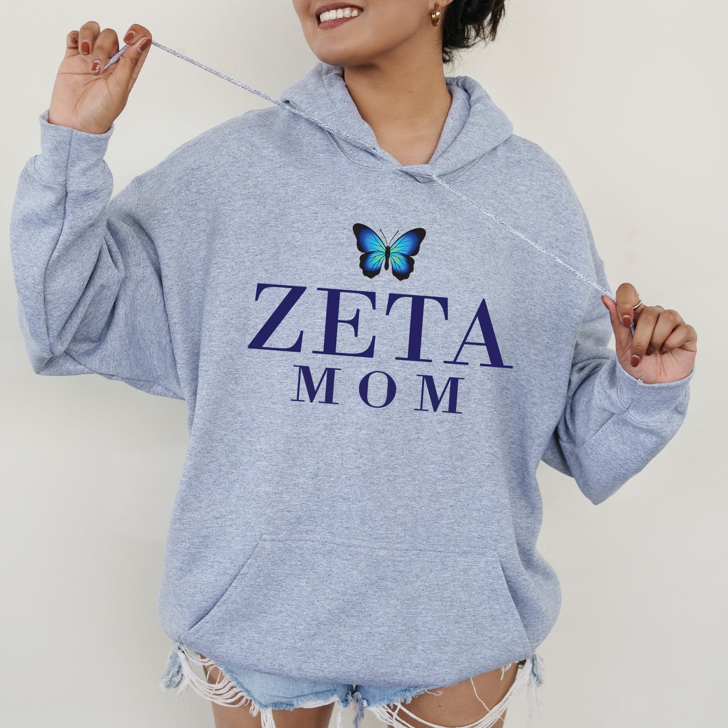 a woman wearing a blue sweatshirt with a butterfly on it