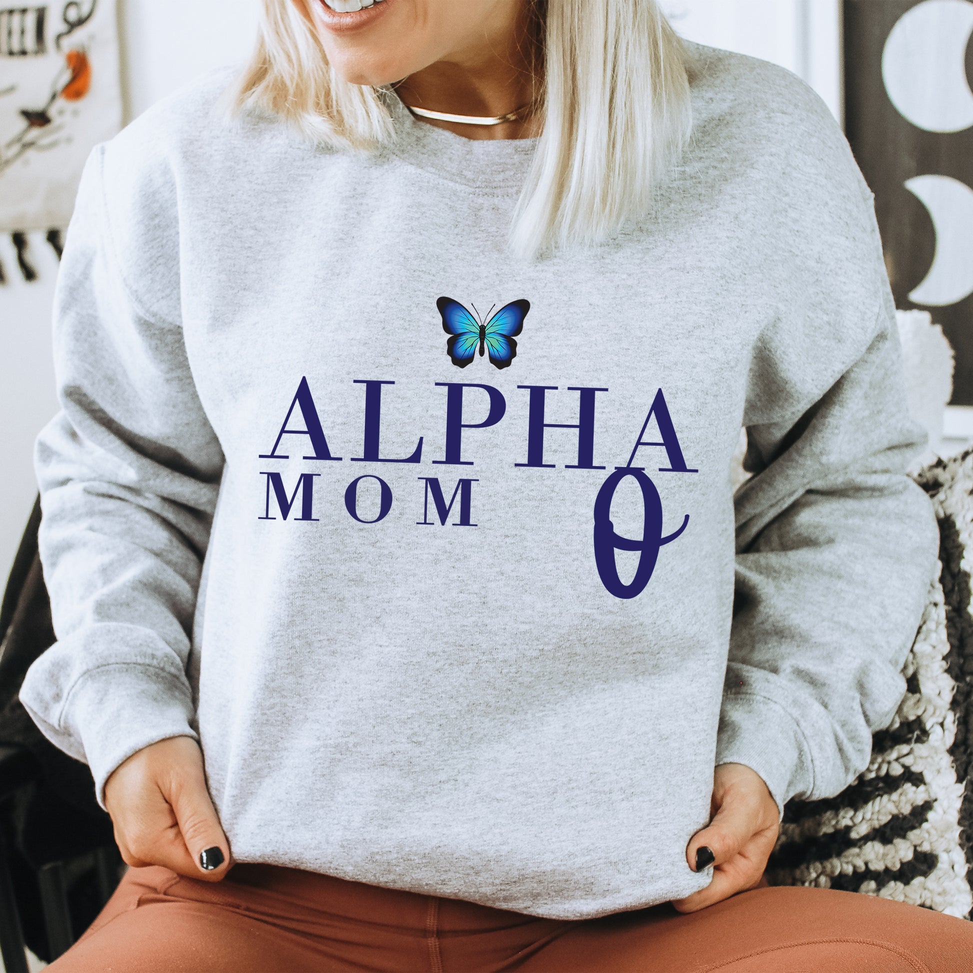 a woman sitting on a chair with a butterfly on her sweatshirt
