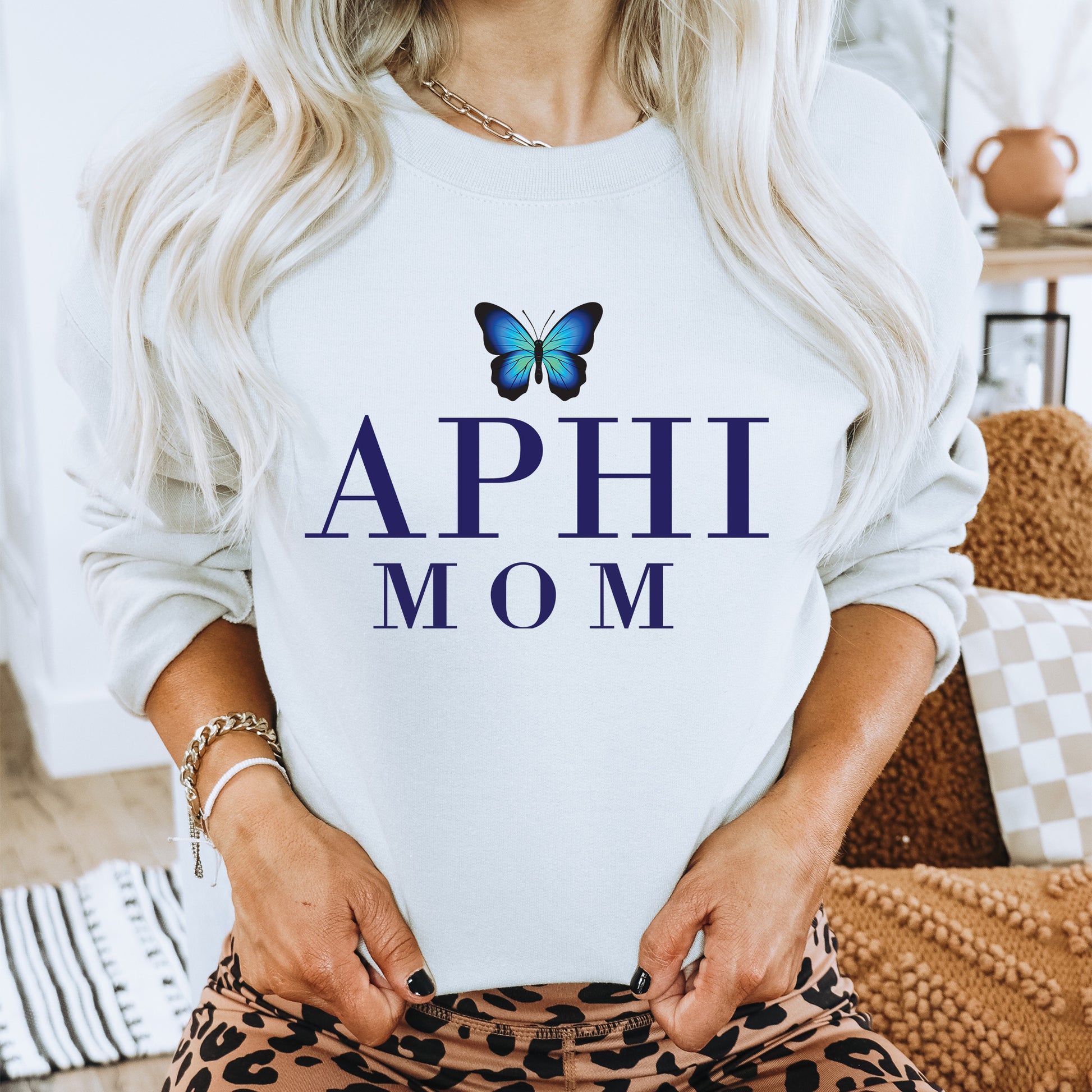 a woman wearing a sweatshirt that says, aphi mom