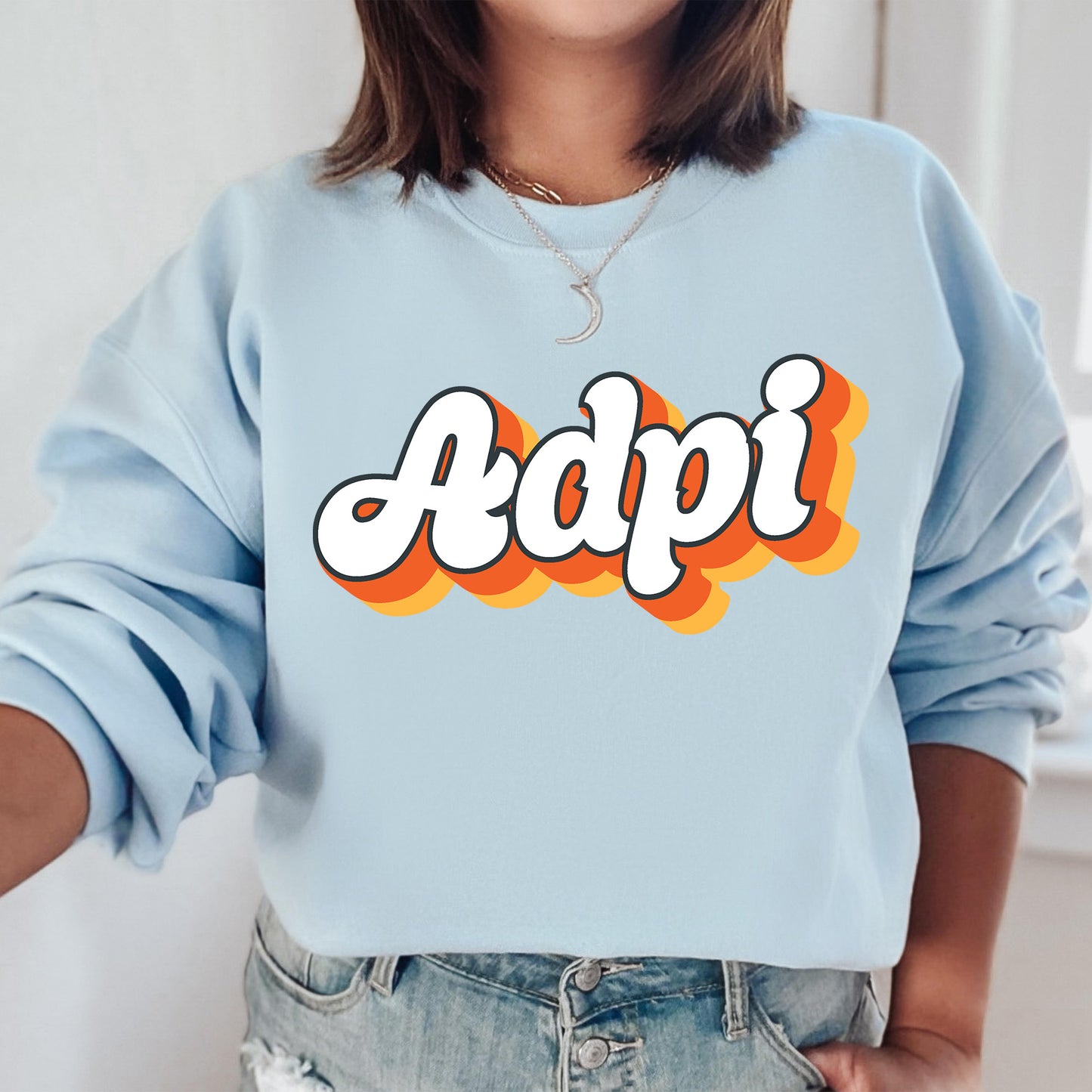 a woman wearing a blue sweatshirt with the word adpi printed on it