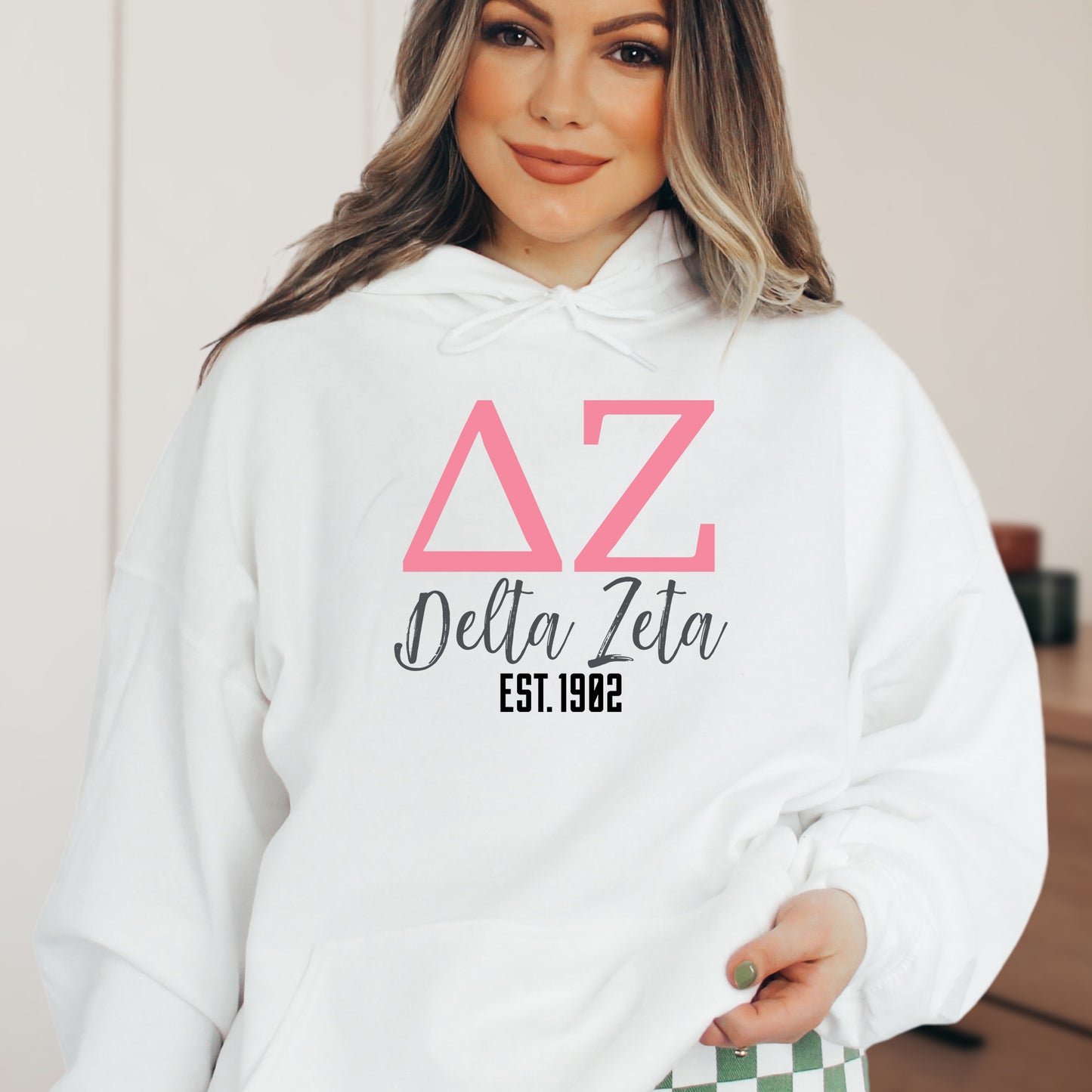 a woman wearing a white hoodie with pink letters