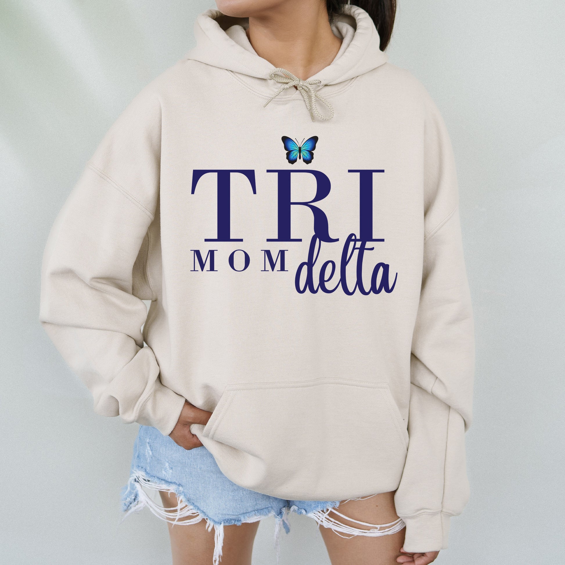 a woman wearing a sweatshirt that says trii mom delta