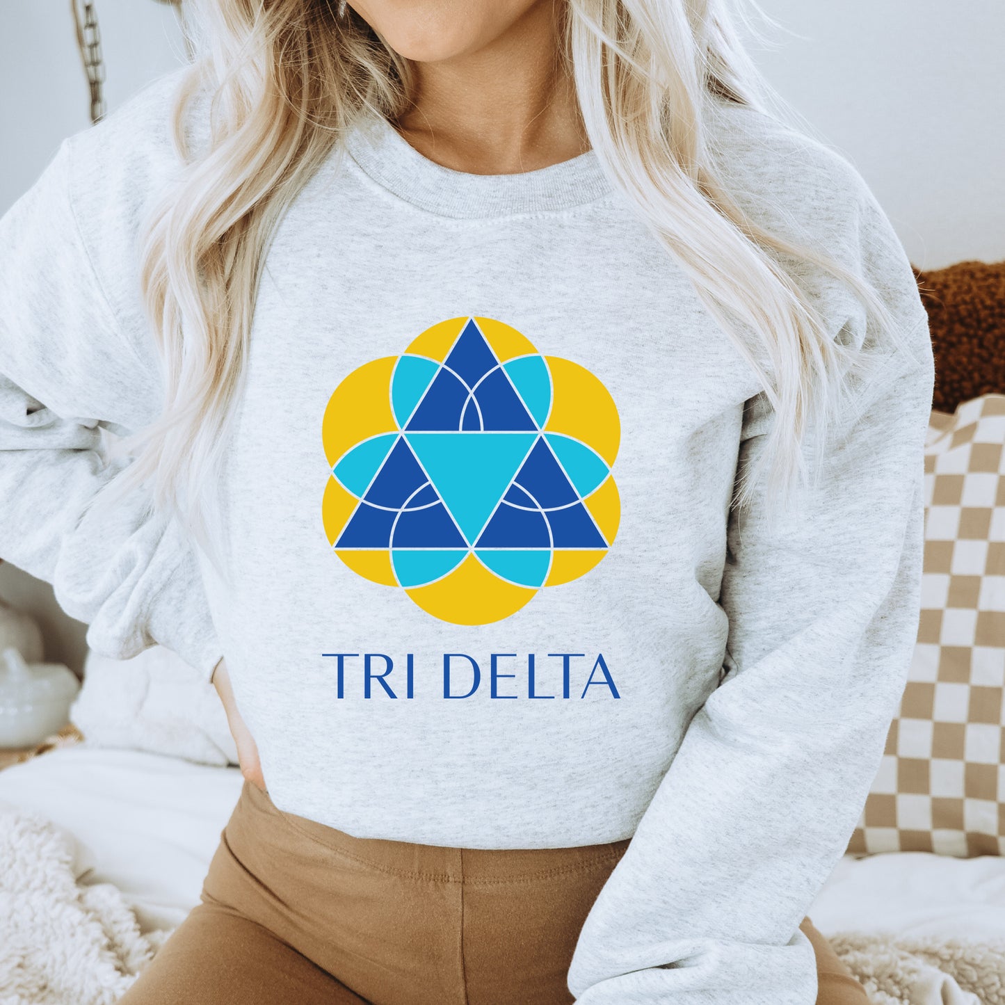 a woman wearing a sweatshirt with the tri delta logo on it