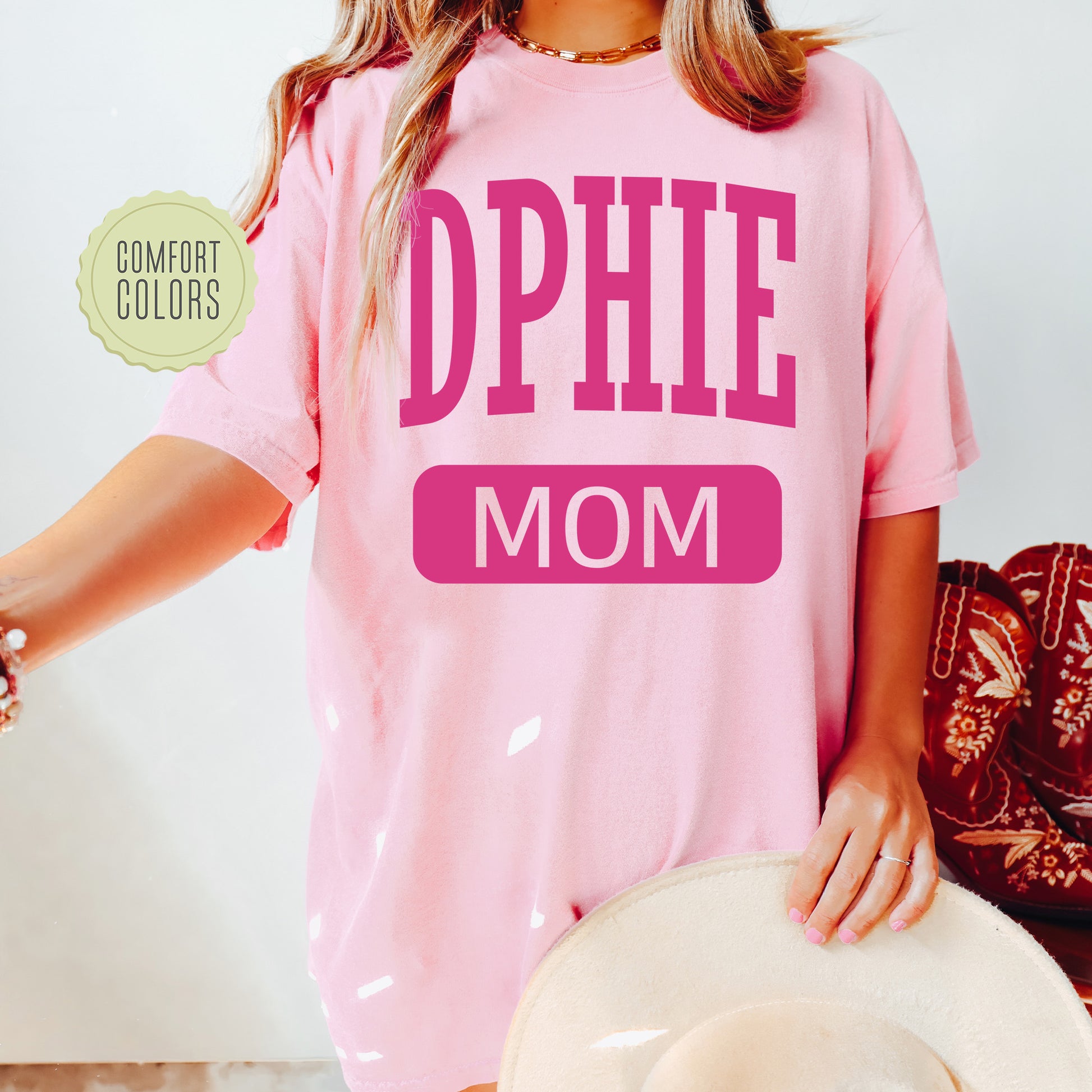 a woman wearing a pink shirt that says ophi mom