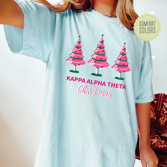 a girl wearing a light blue shirt with pink trees on it