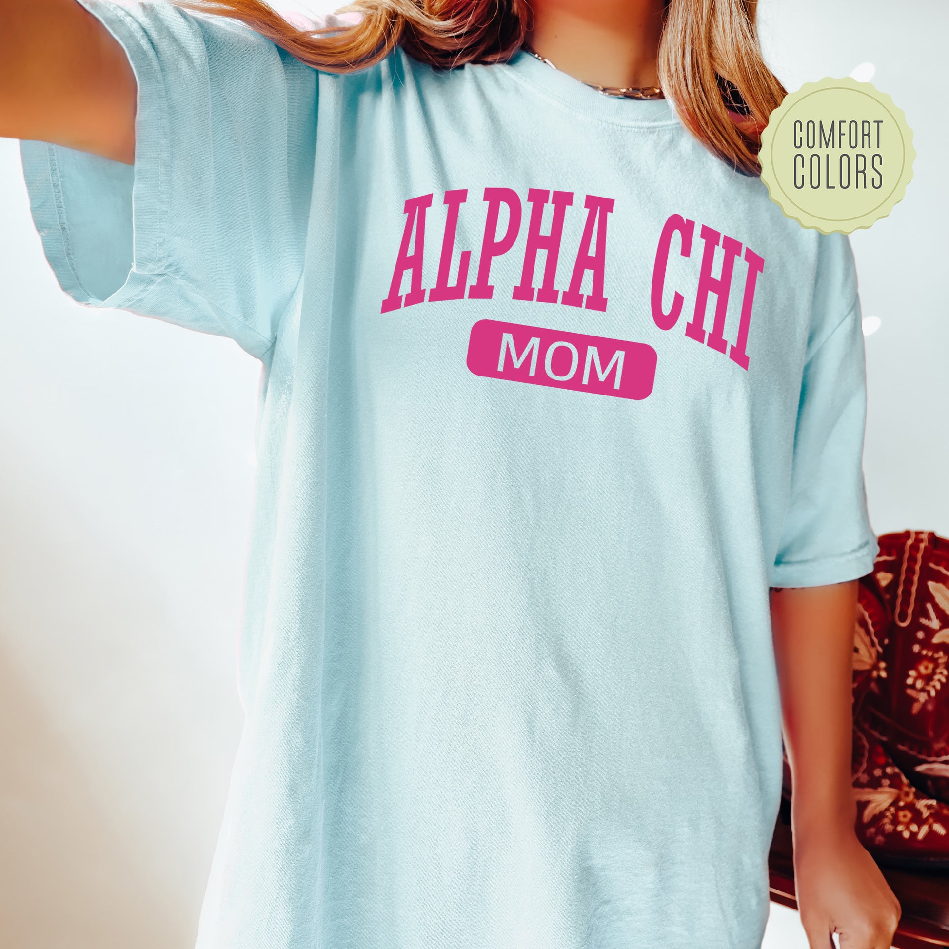 a woman wearing a light blue shirt with pink letters on it