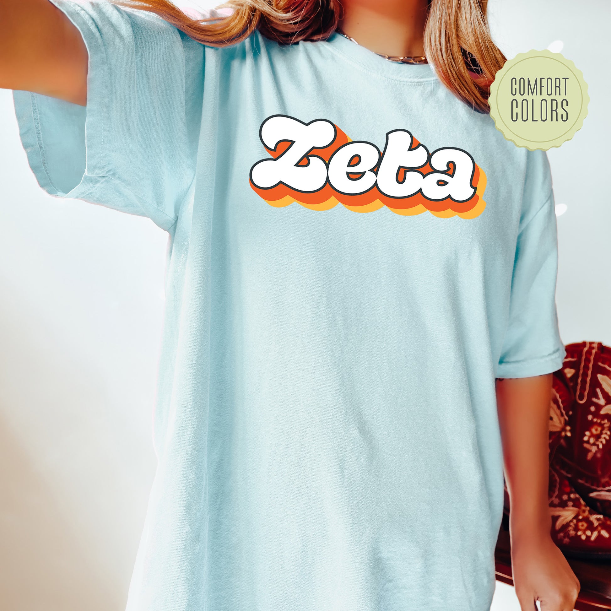 a woman wearing a blue shirt with the word zeta on it