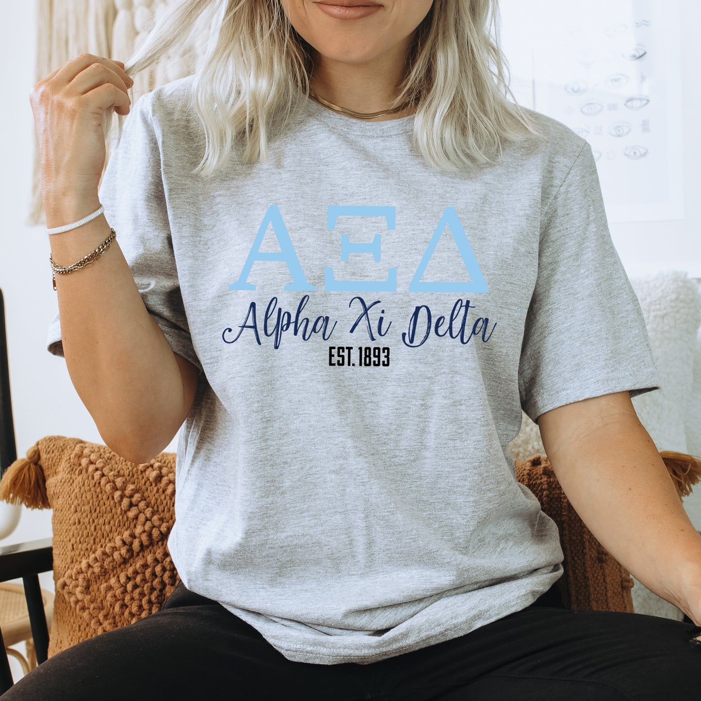 a woman sitting on a chair wearing a delta shirt