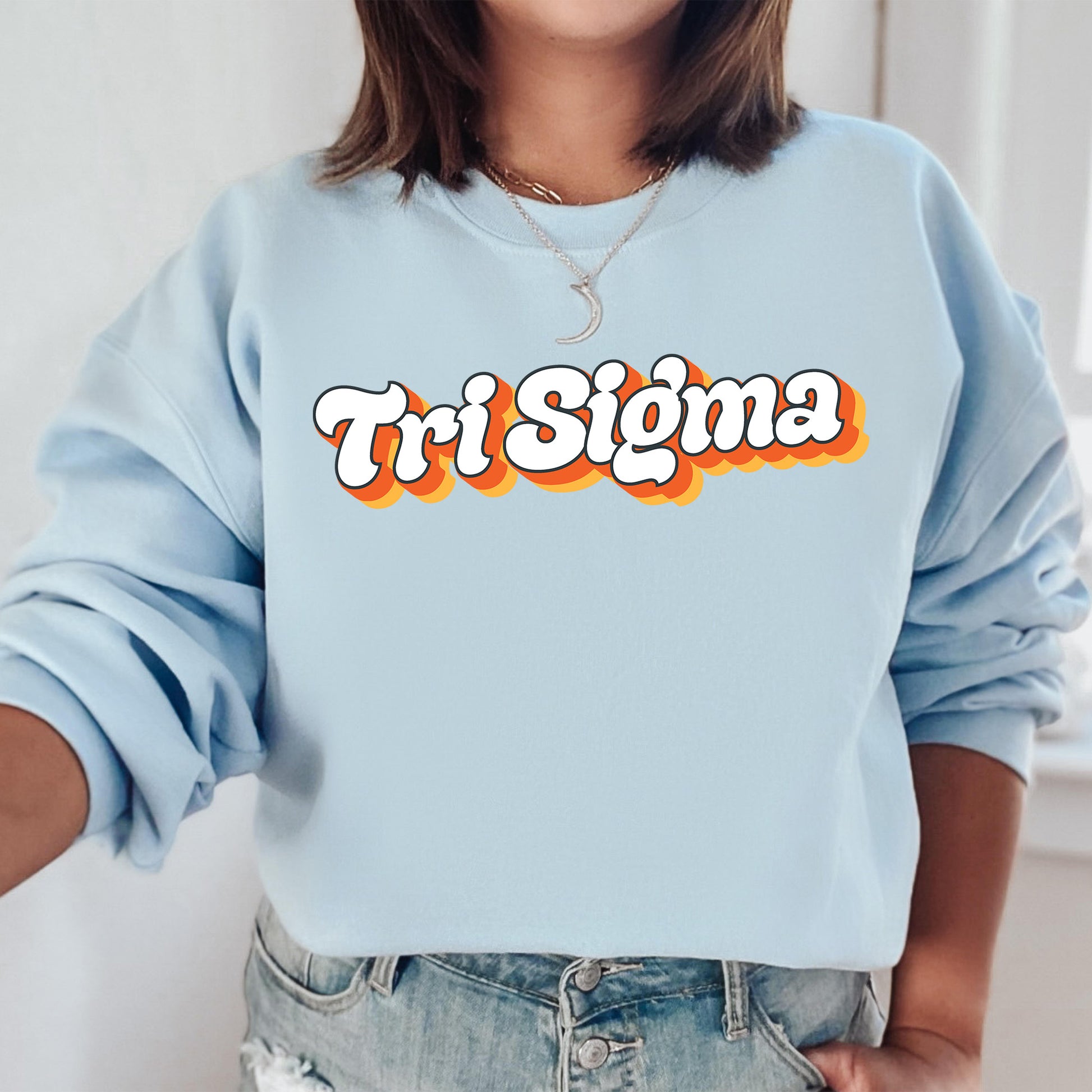 a woman wearing a blue sweatshirt that says tri sigma