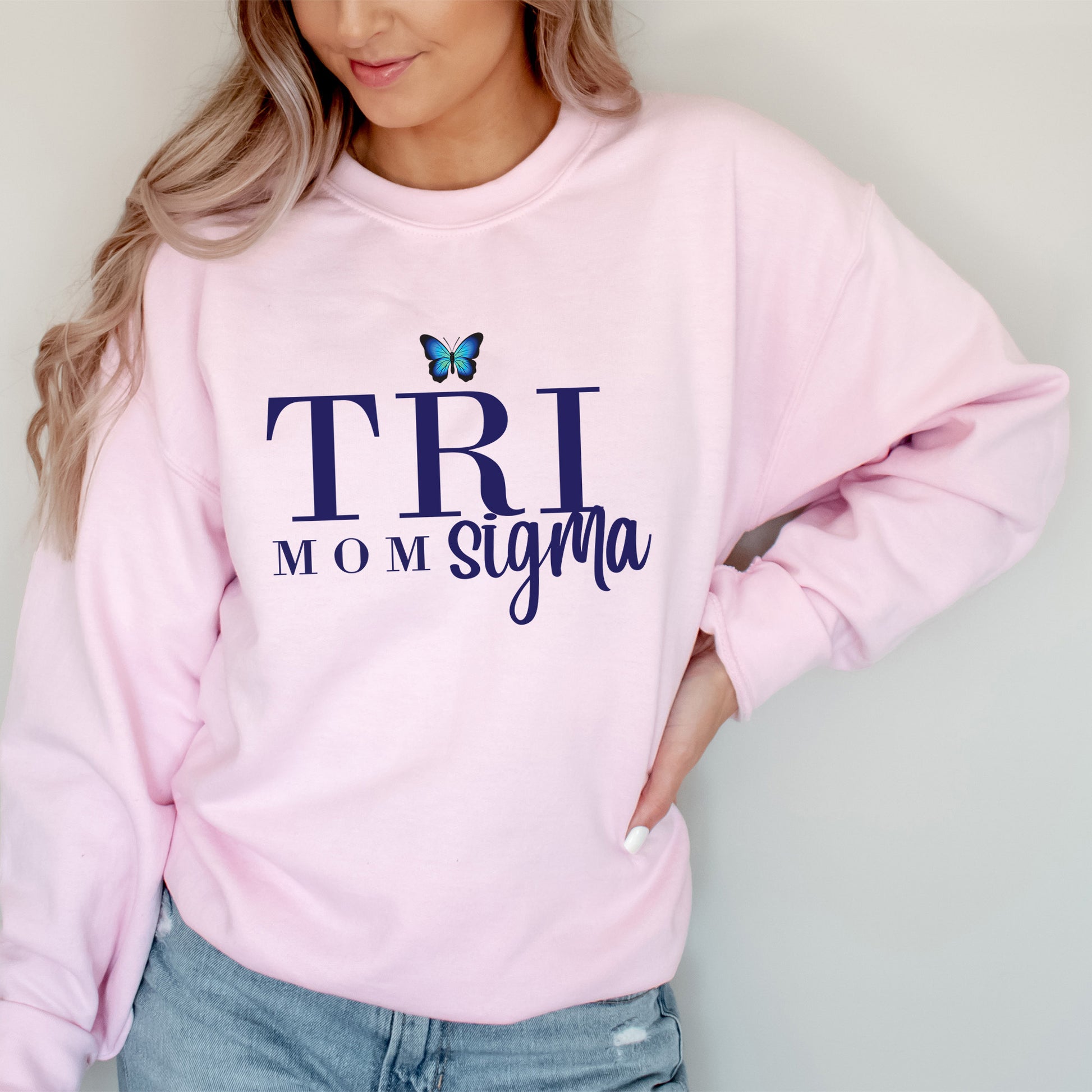 a woman wearing a pink shirt with the words tri mom on it