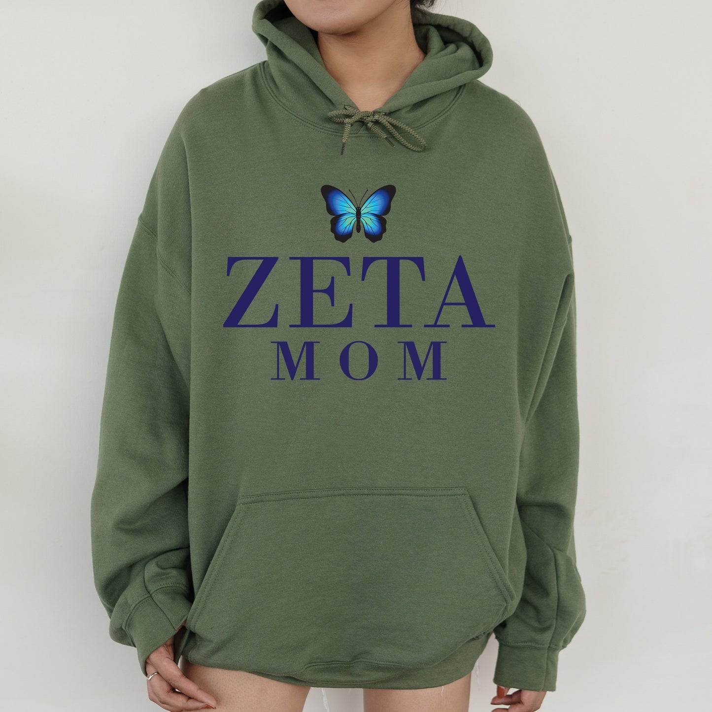 a woman wearing a green hoodie with a blue butterfly on it