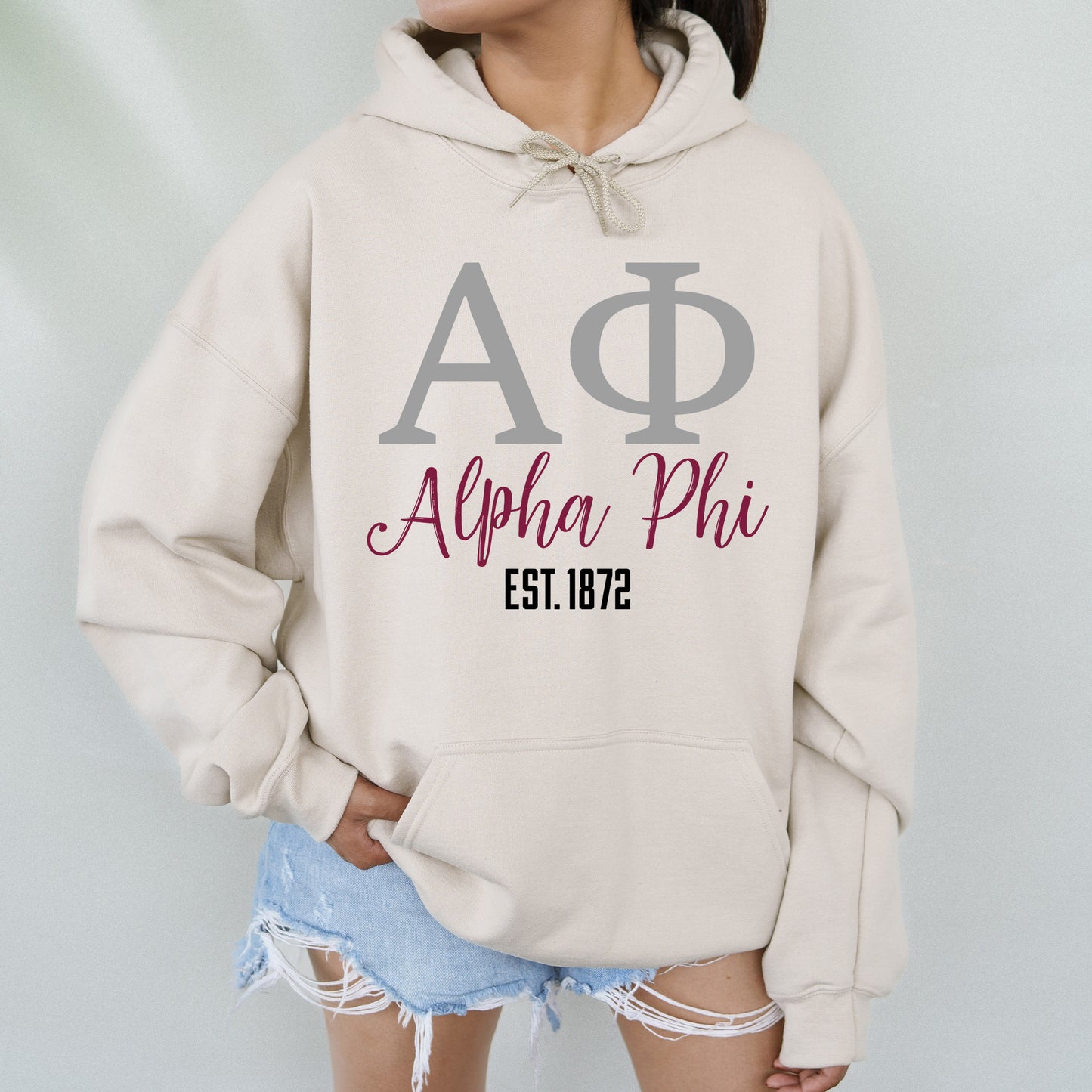 a woman wearing a hoodie with the letters ap and phi on it
