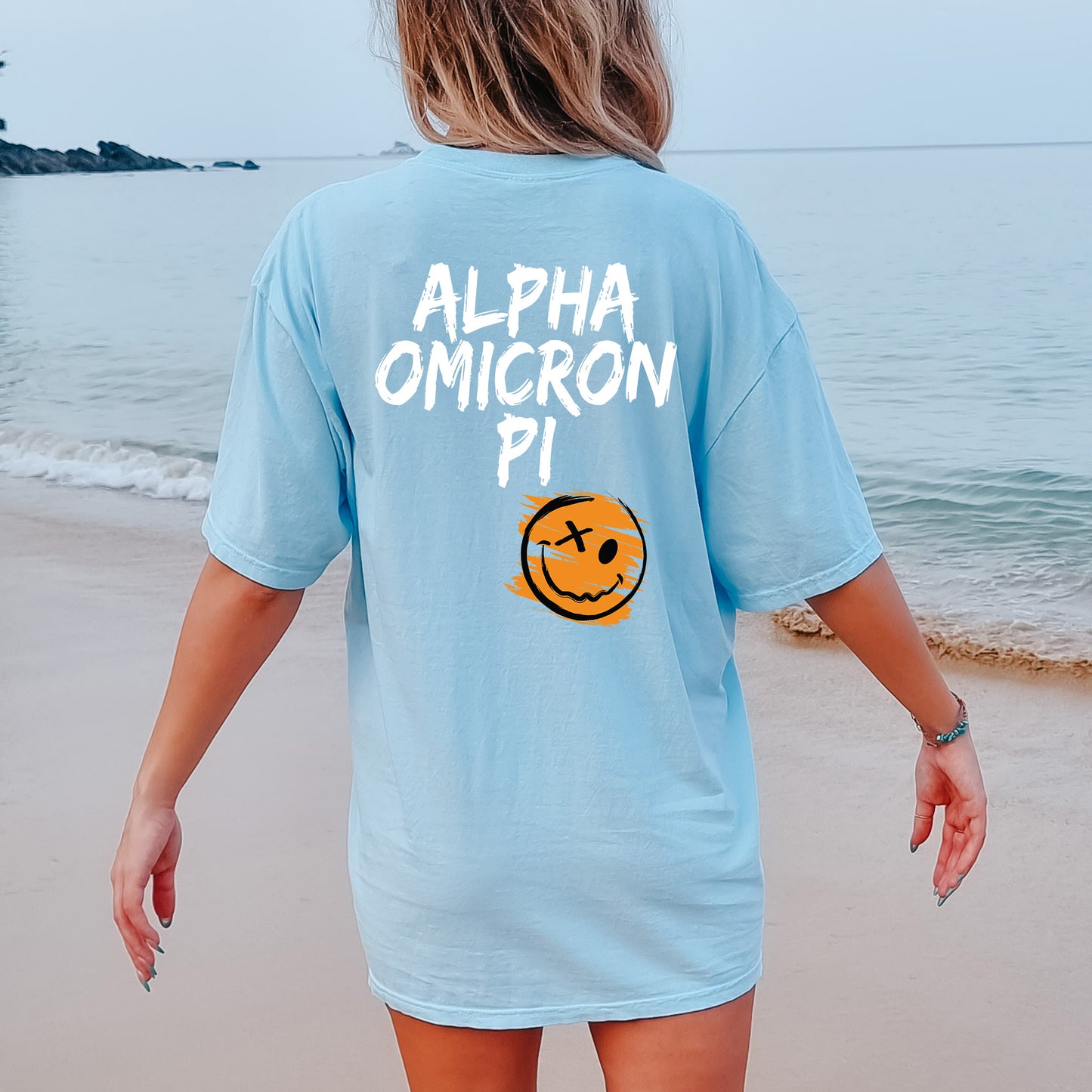 a woman walking on the beach with a smile on her shirt