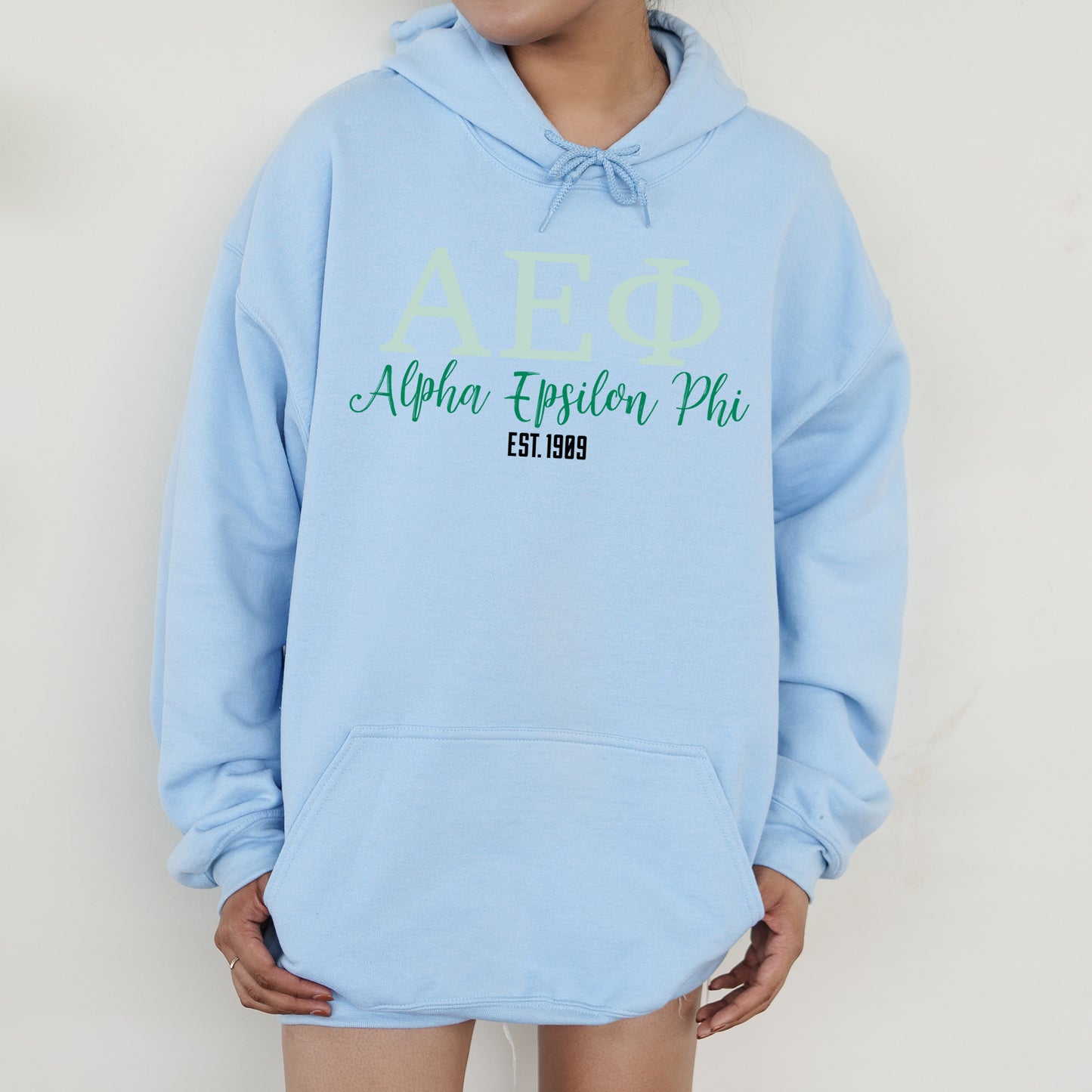 a person wearing a blue hoodie with green letters on it