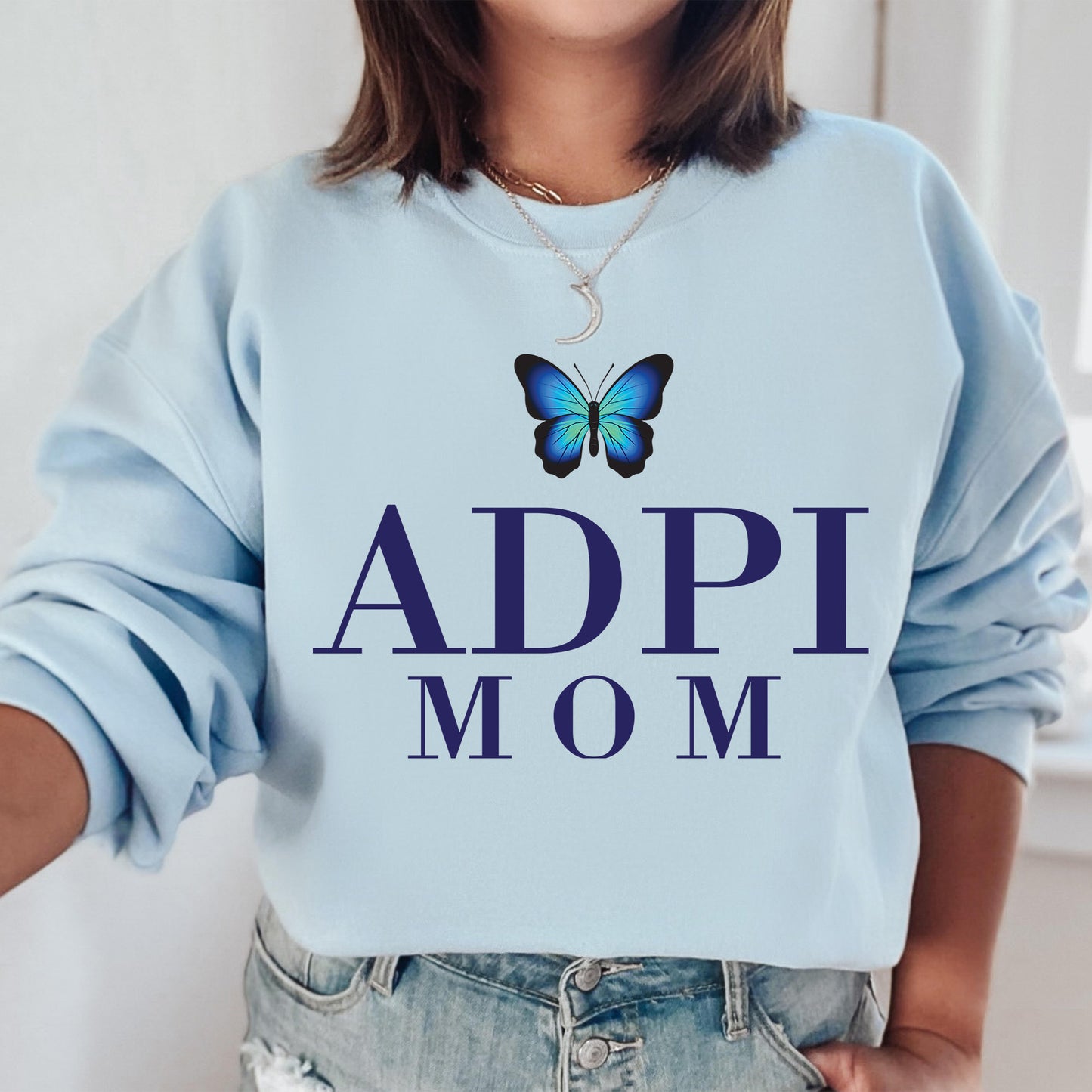 a woman wearing a blue sweatshirt with a butterfly on it