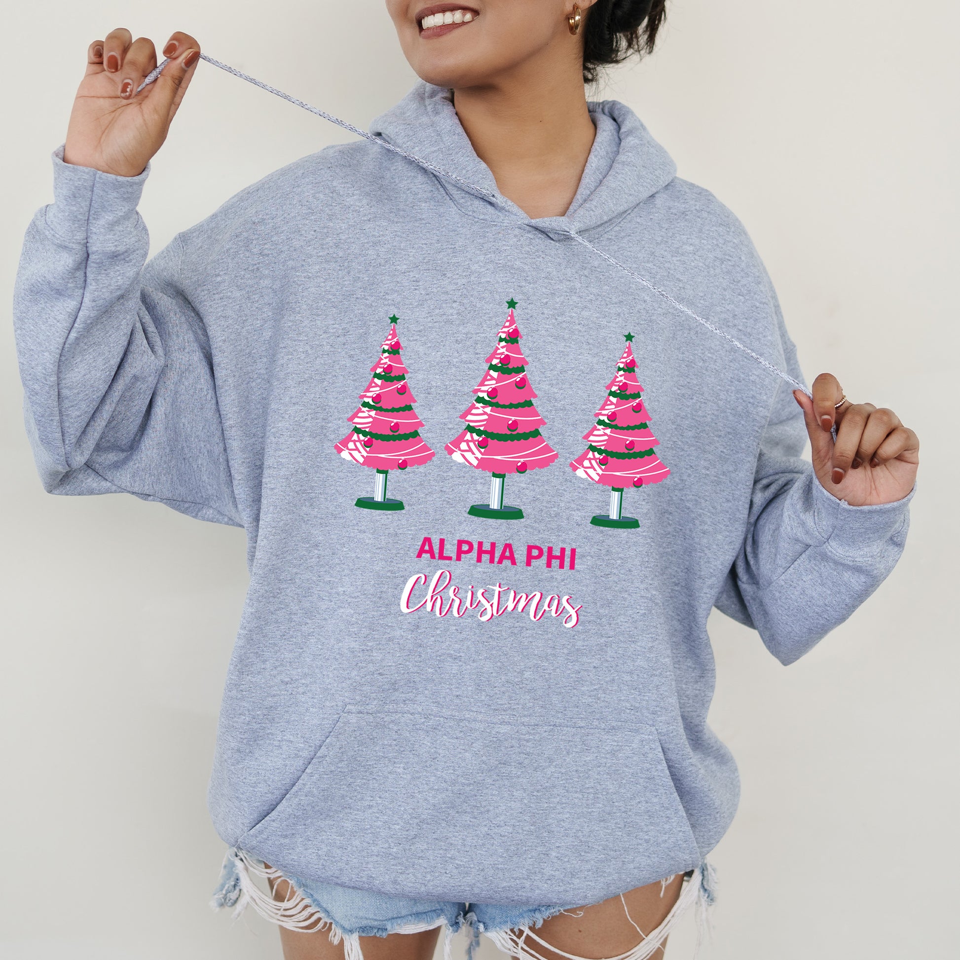 a woman wearing a sweatshirt with christmas trees on it