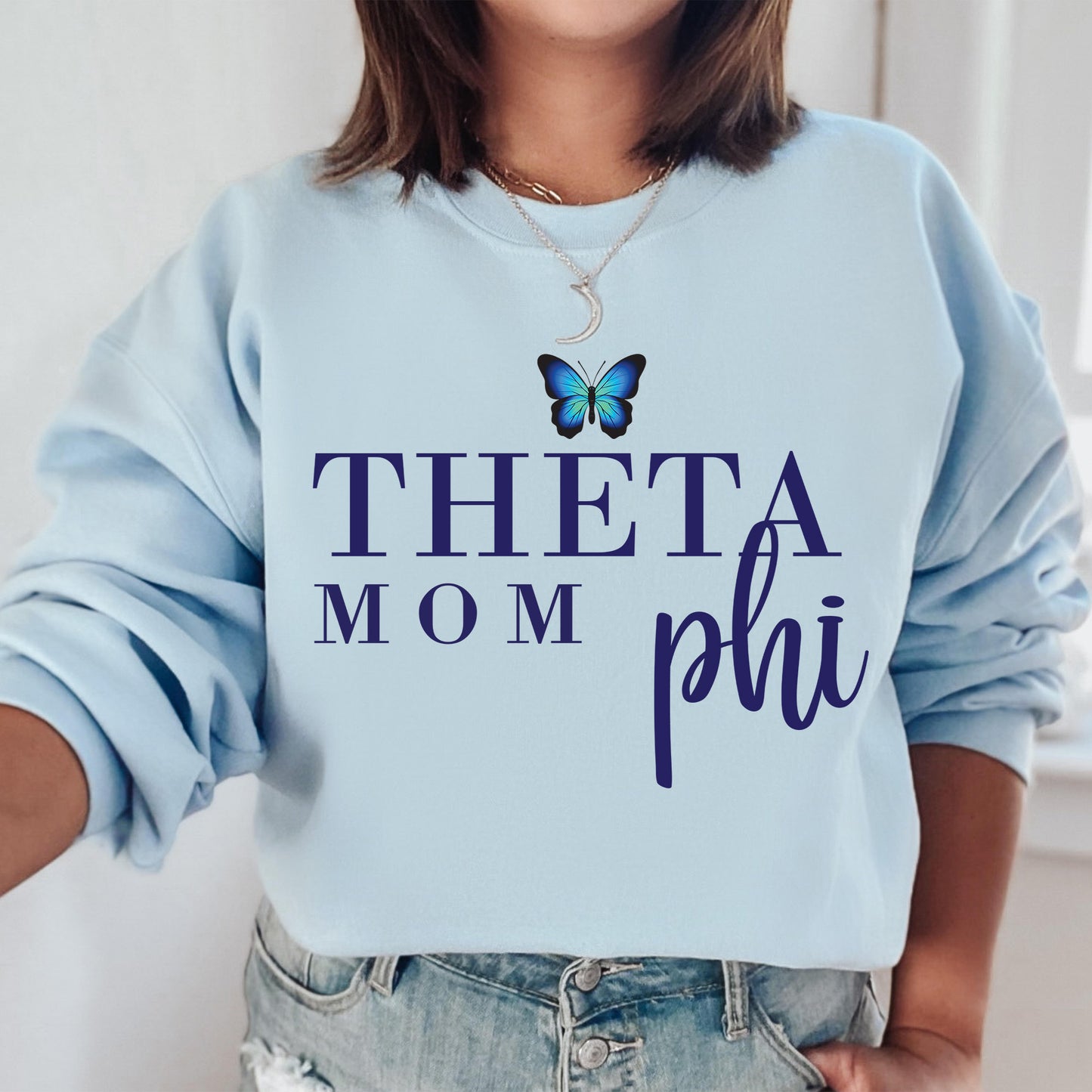 a woman wearing a sweatshirt that says, thea mom phi