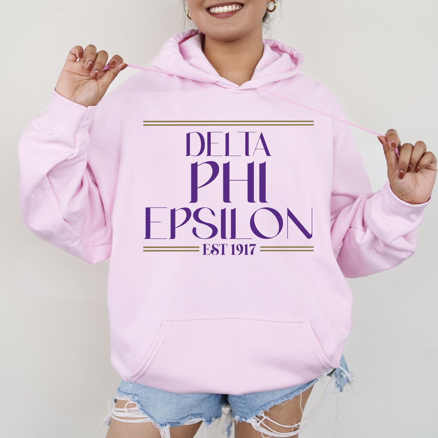 a woman wearing a pink hoodie that says delta phi epsion