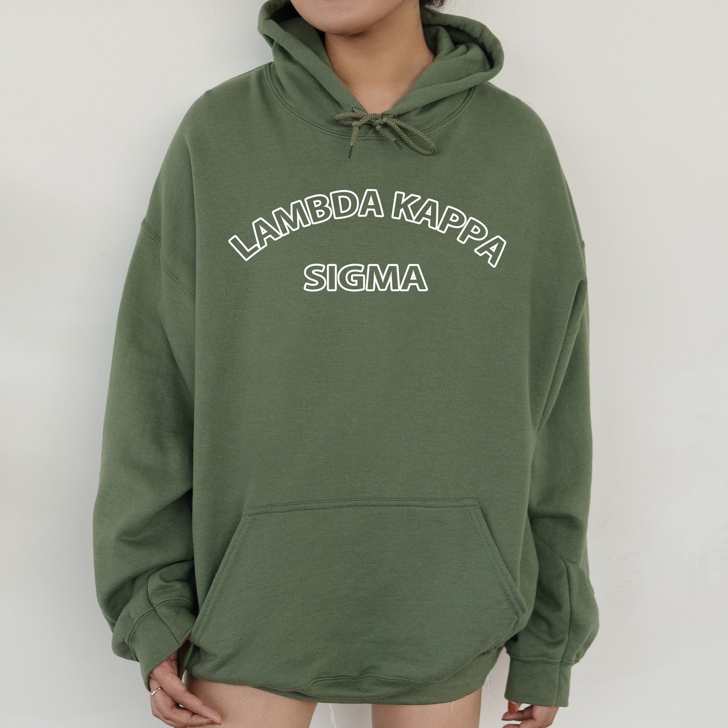 a woman wearing a green hoodie that says lambda kapa stigma