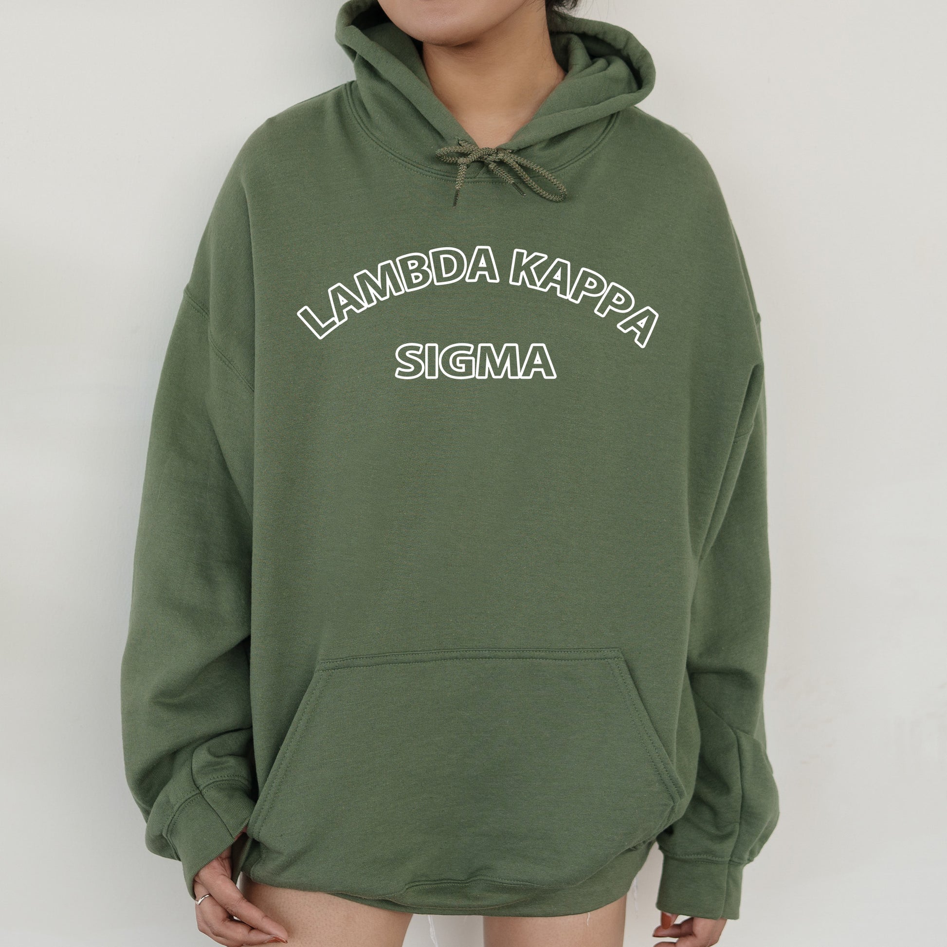 a woman wearing a green hoodie that says lambda kapa stigma