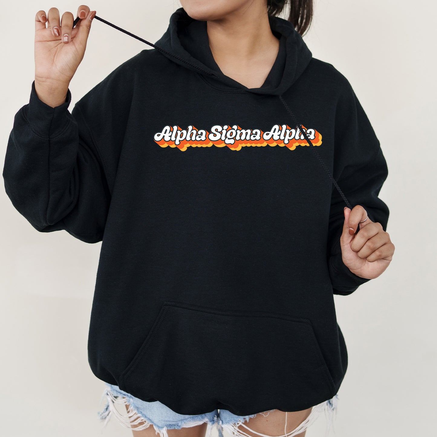 a woman in a black hoodie holding a cigarette