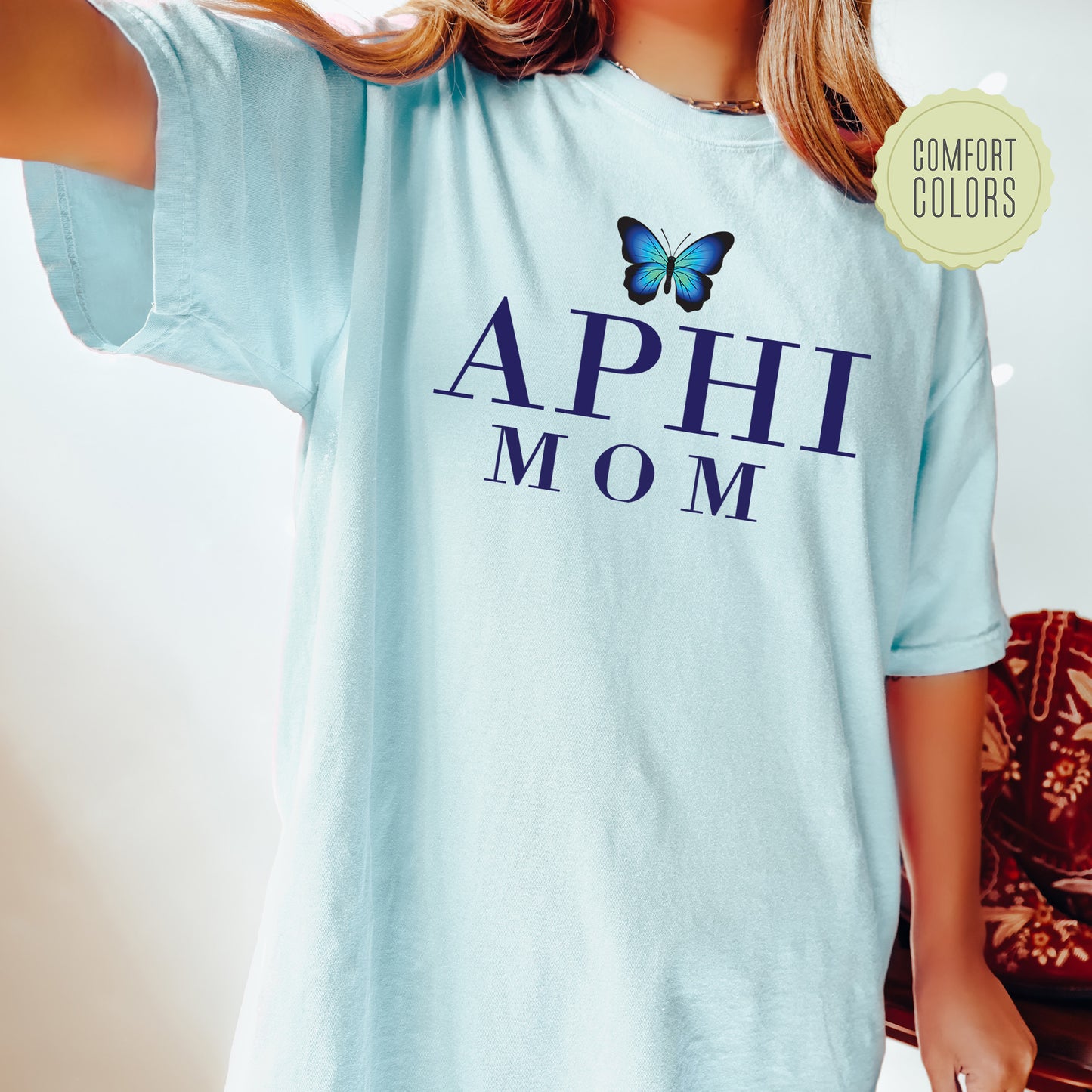 a young girl wearing a blue shirt with a butterfly on it