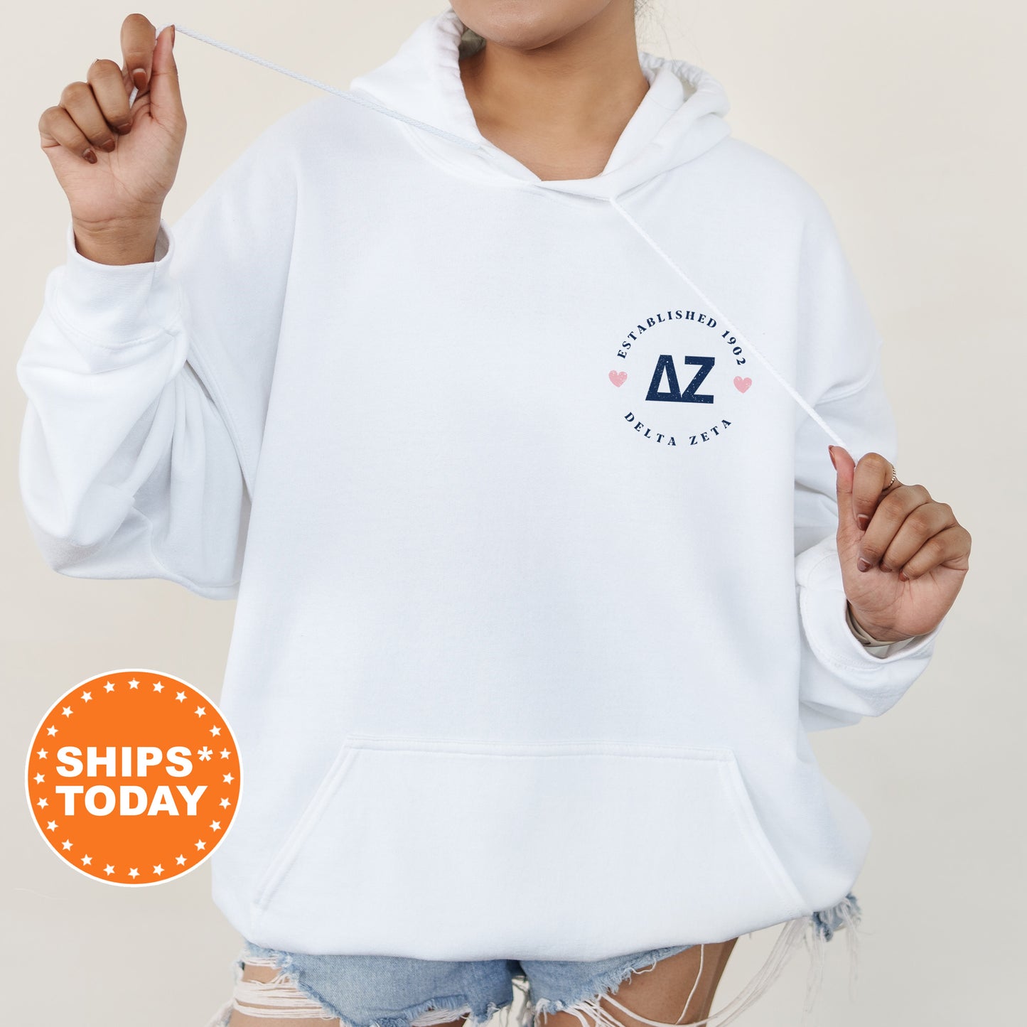 a woman in a white hoodie holding a toothbrush