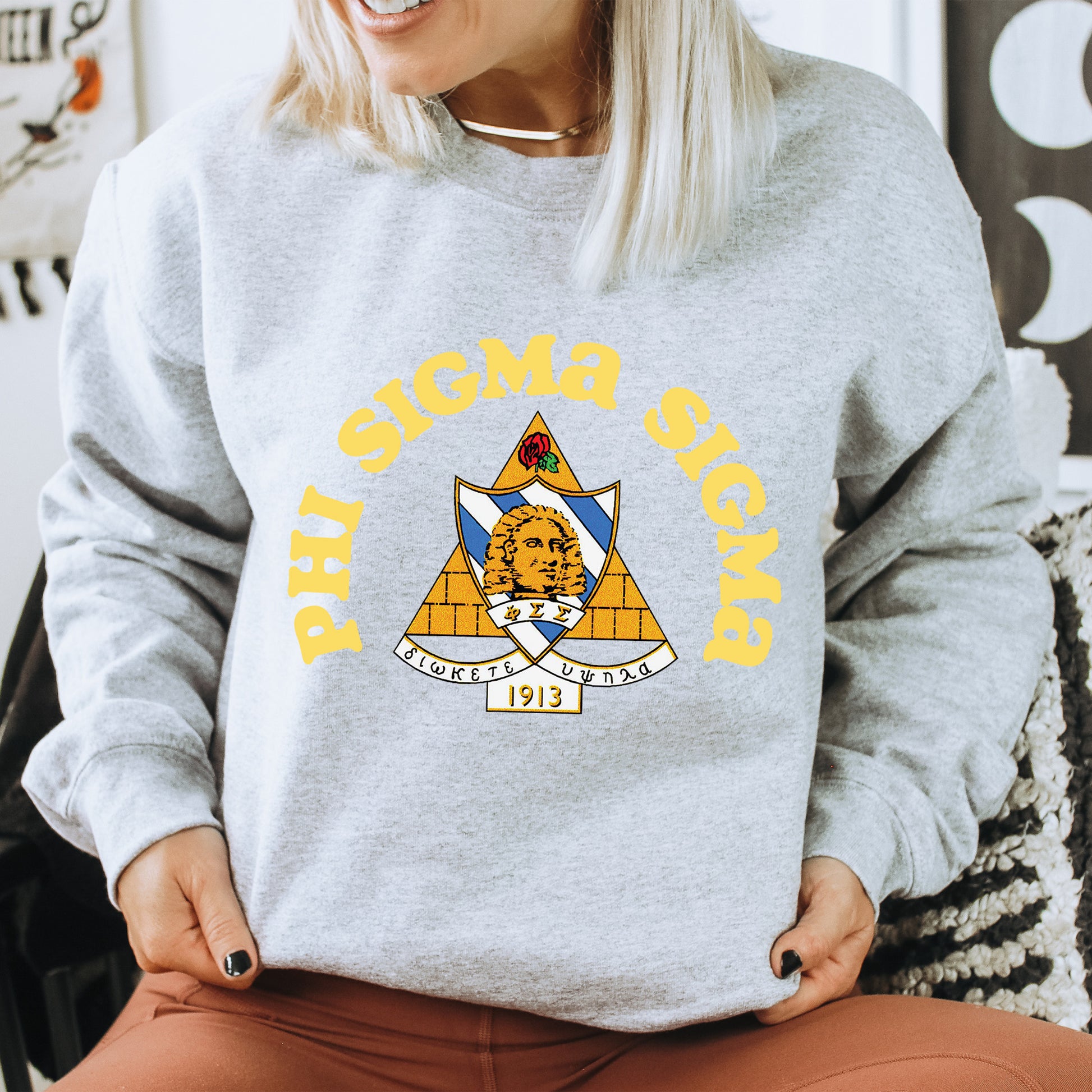 a woman sitting on a chair wearing a grey sweatshirt