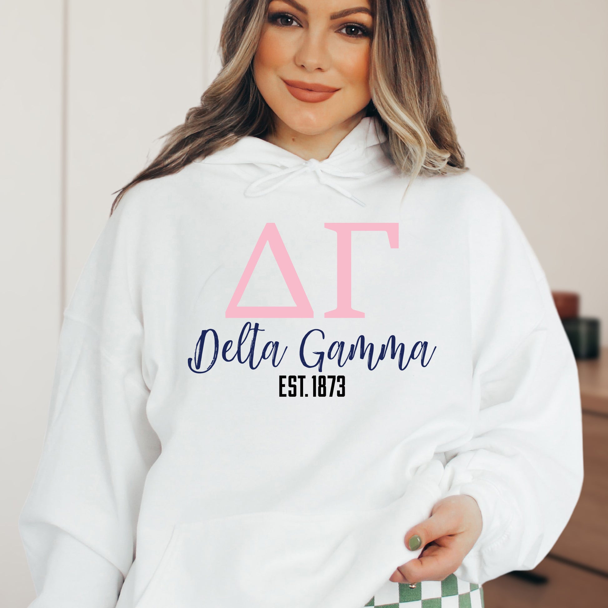 a woman wearing a white hoodie with pink letters