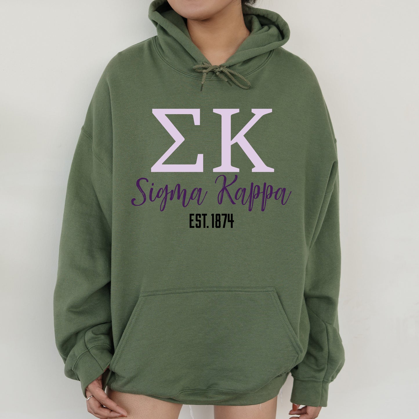 a woman wearing a green hoodie with the letter zk on it