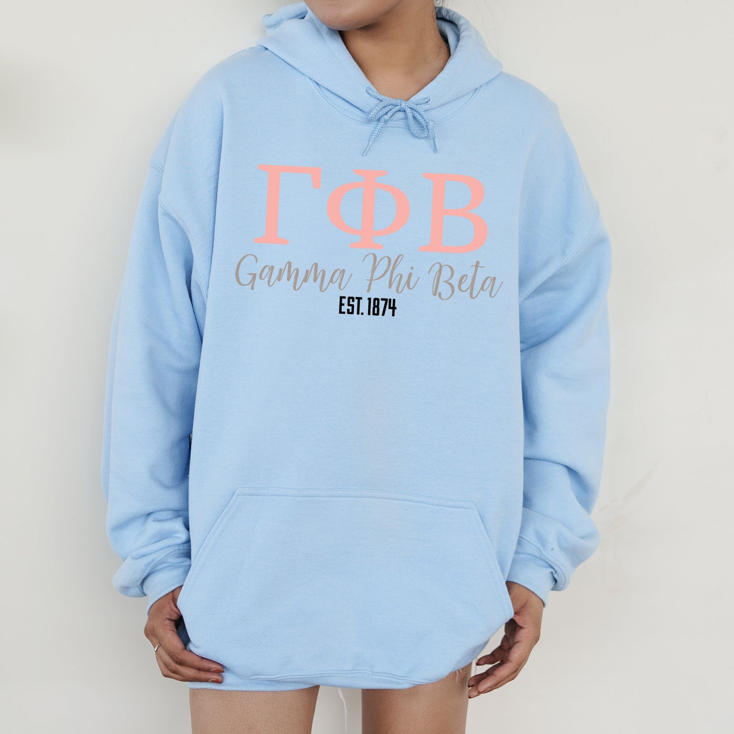 a woman wearing a light blue hoodie with the word top on it